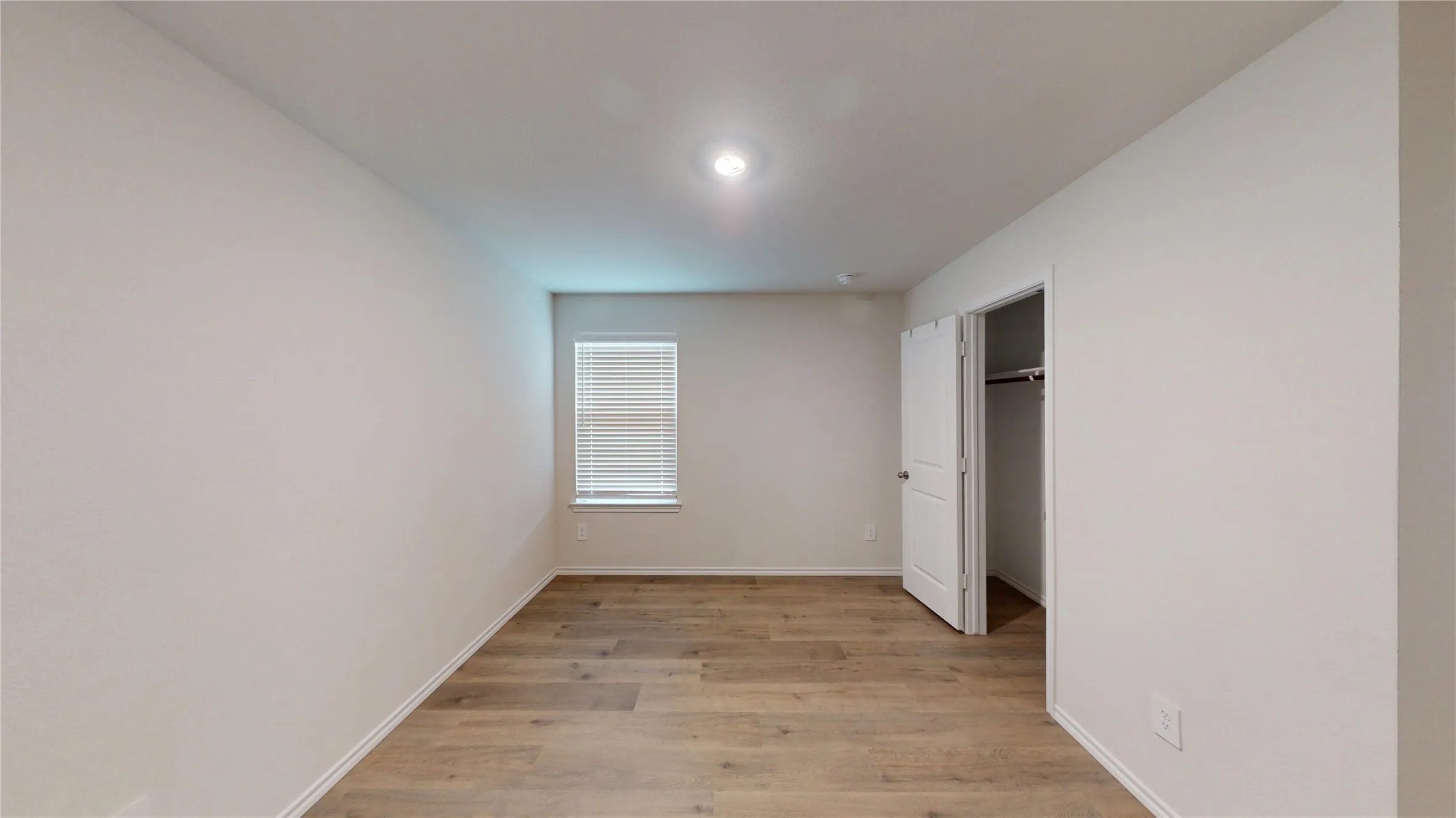 Recessed ceiling lighting, wood-finish flooring, white paneled door, and window with horizontal blinds