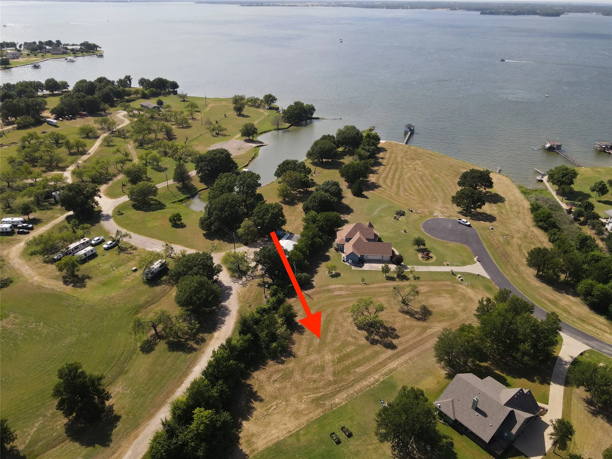 Cleared lot with mature trees and a gently sloped terrain
