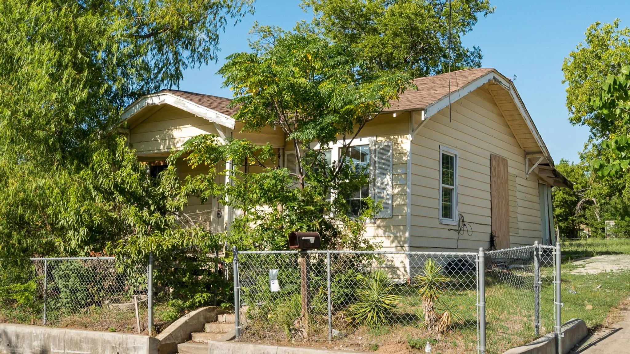 Overgrown trees in the front of this home.