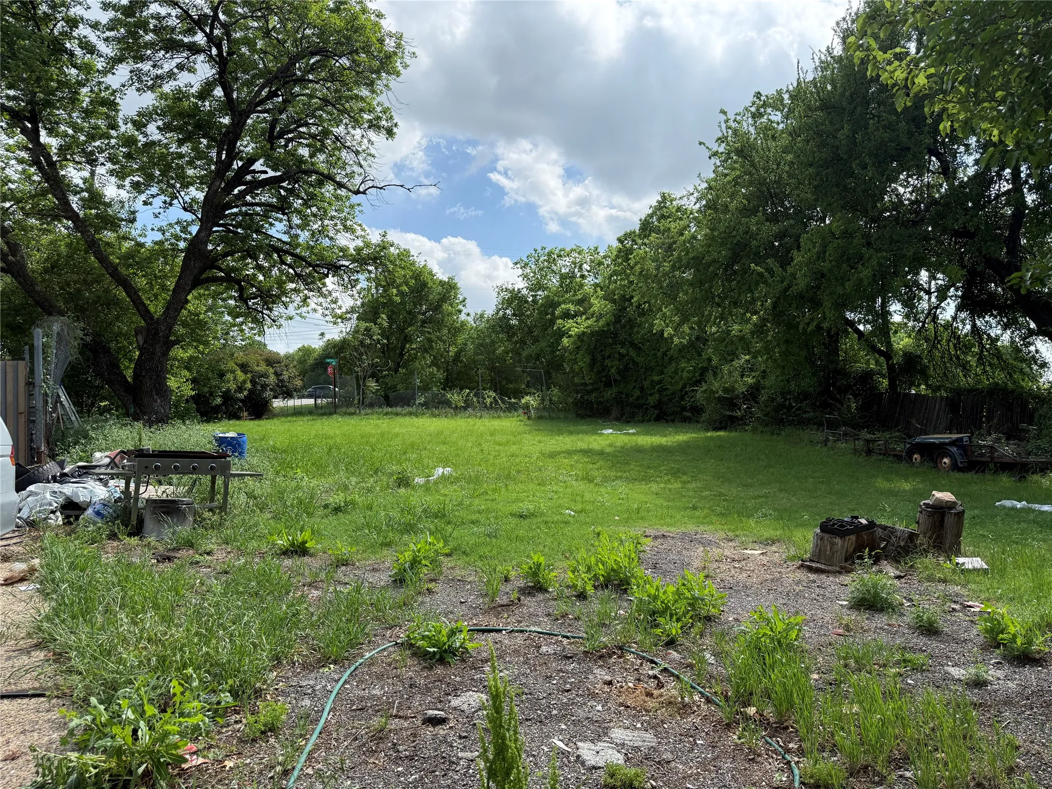 Expansive grassy area surrounded by mature trees, offering a private outdoor environment