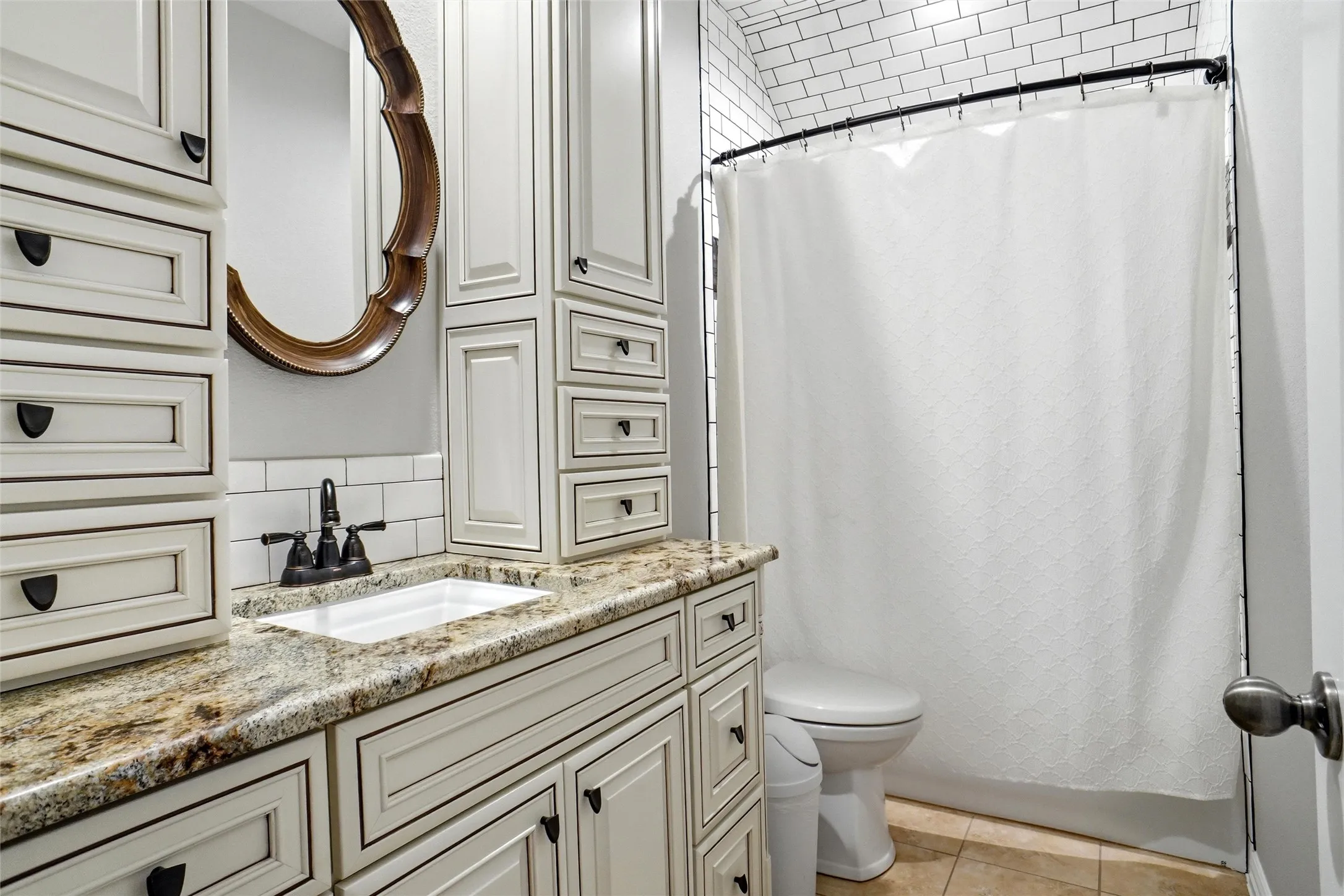 Bathroom vanity featuring a built-in sink, granite countertop, and extensive cabinetry