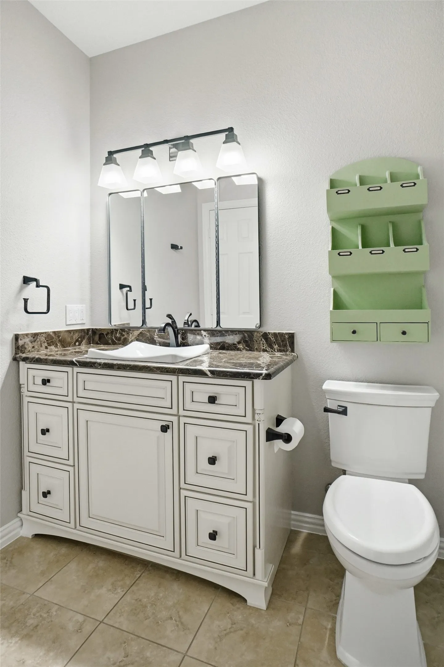 Bathroom featuring a white vanity with a dark countertop, white undermount sink, and dark-finish faucet