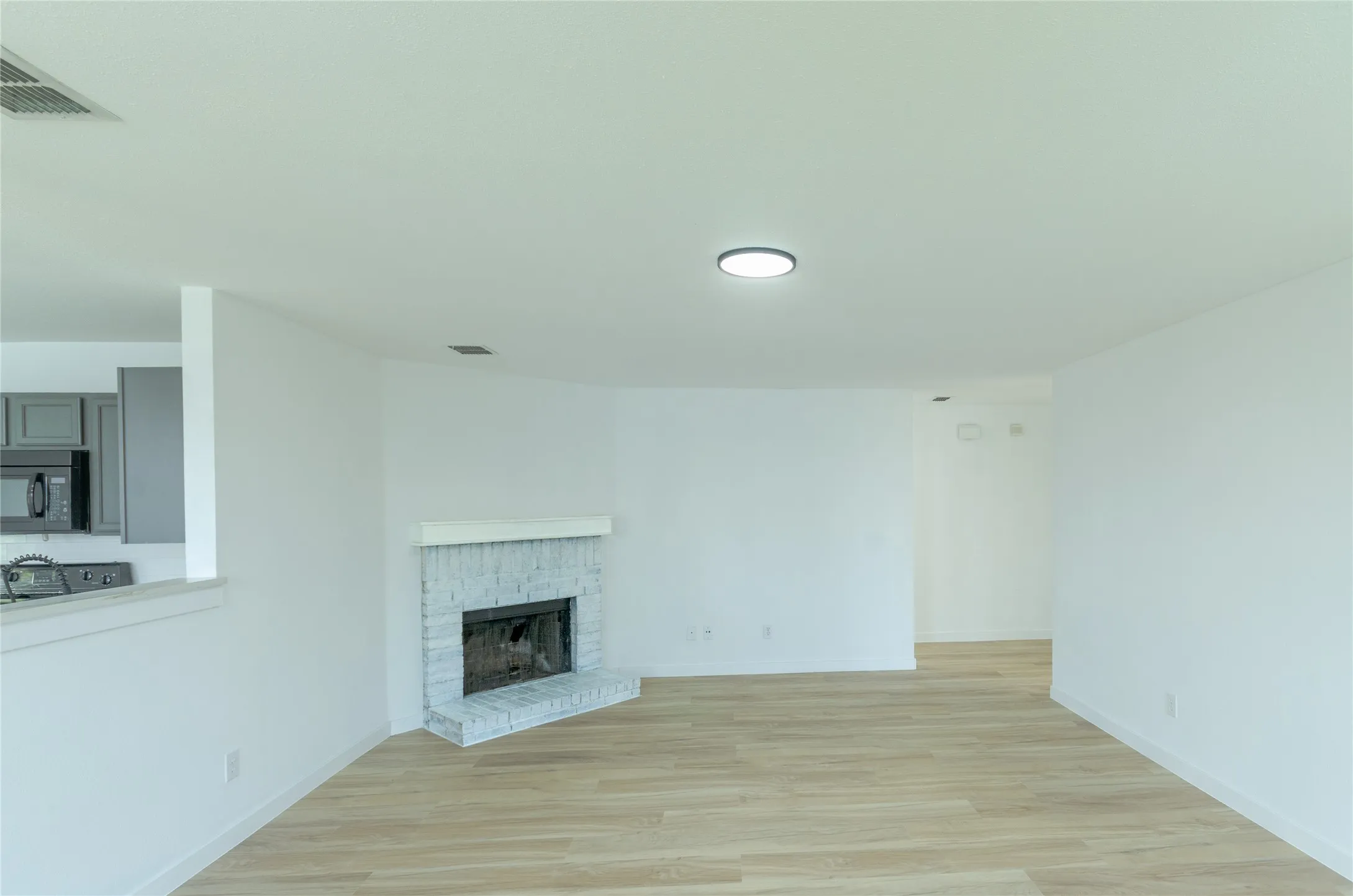 Open-concept living space with light wood-finish flooring