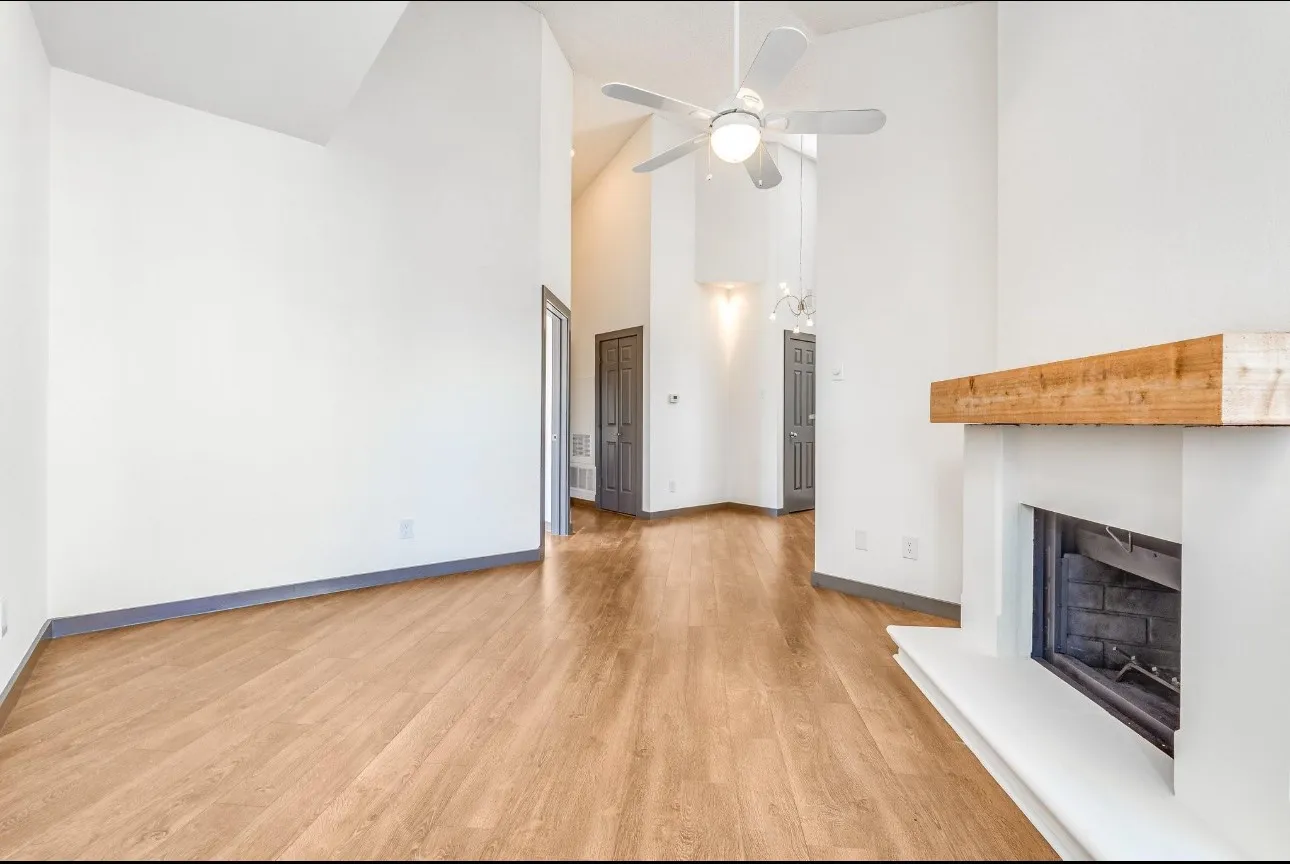 Unfurnished living room with ceiling fan, high vaulted ceiling, and light hardwood / wood-style flooring