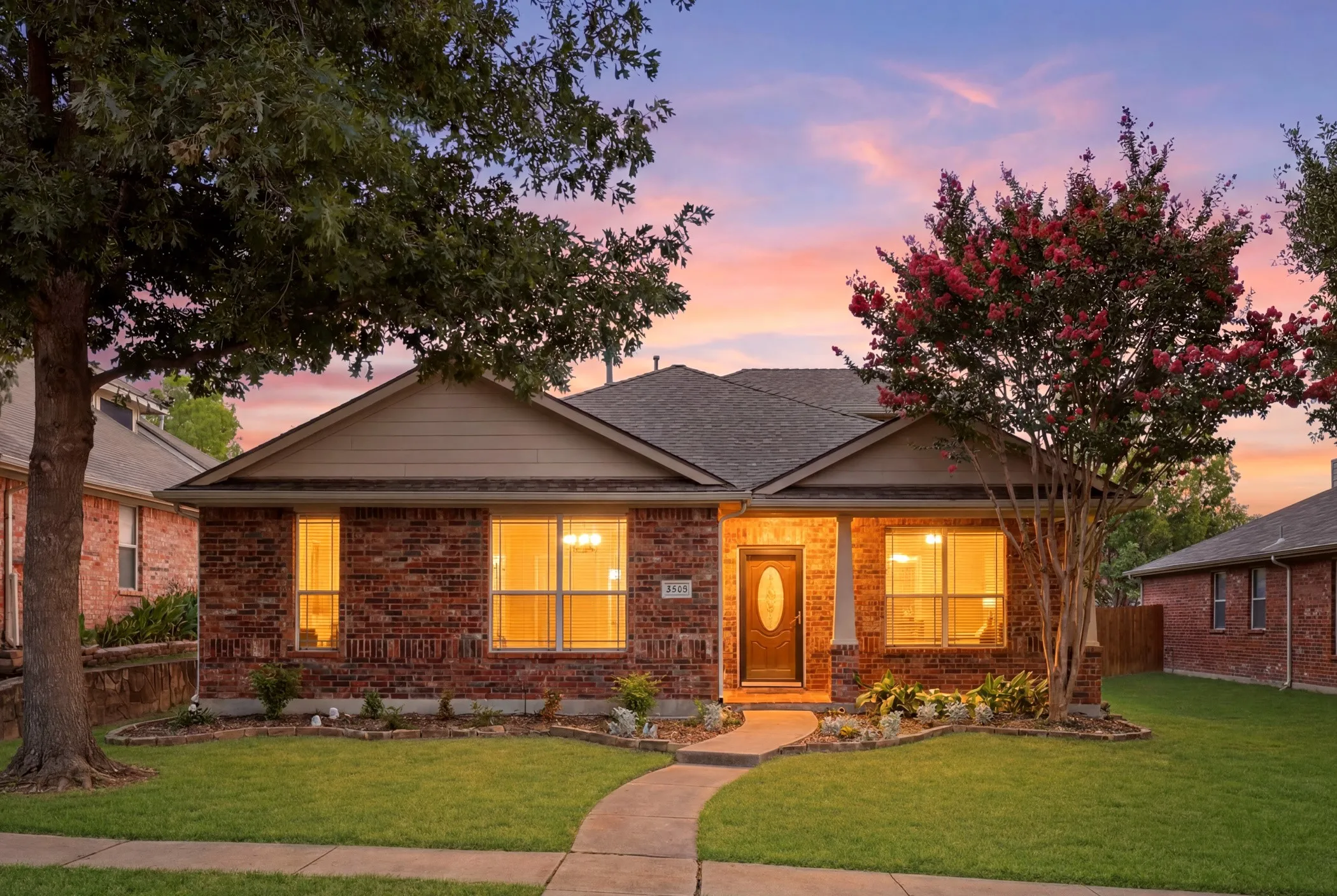 Brick exterior with a covered front porch and a dark wood door featuring an oval-shaped glass insert