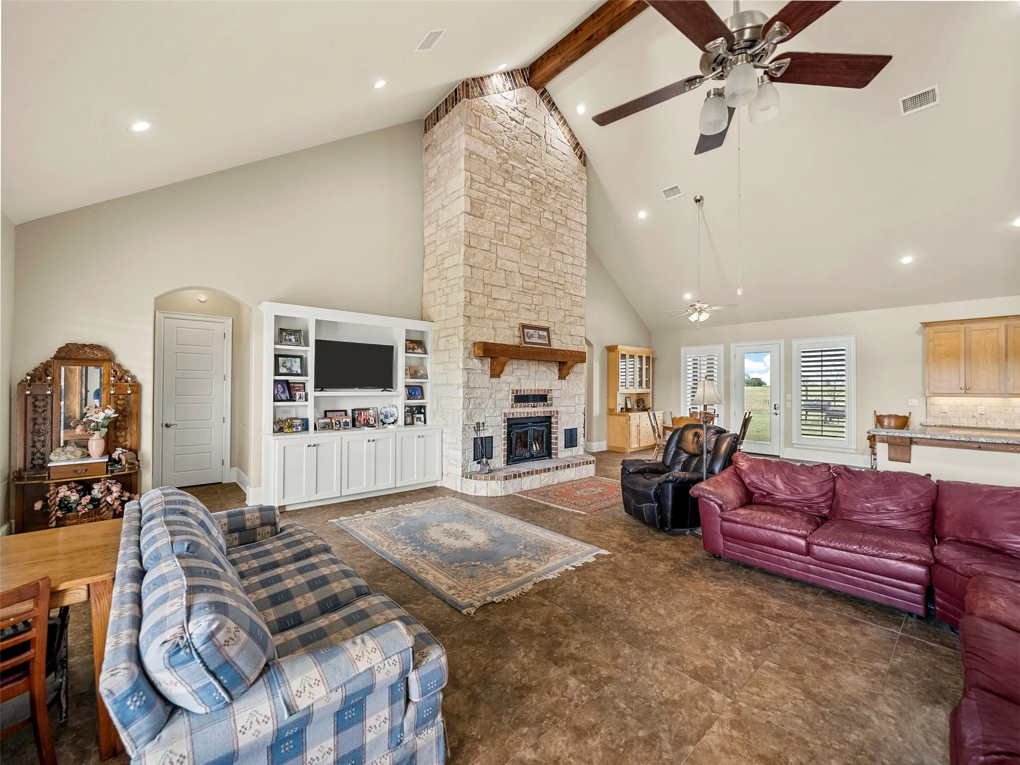 LIVING ROOM...Tile Floor, Vaulted Ceiling, Stone W/B Fireplace With Insert, Built-Ins, Open To Kitchen And Dining Areas