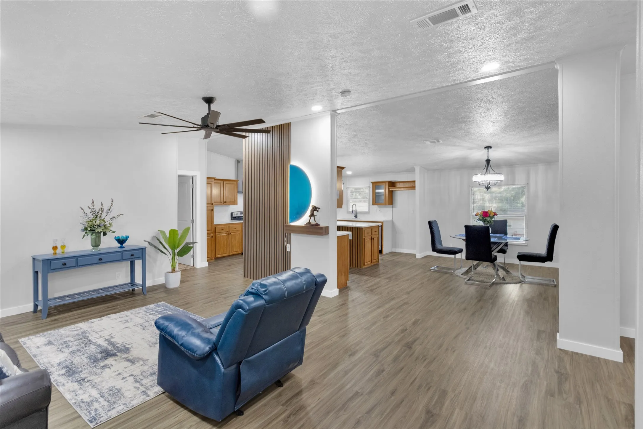 Open-concept living area featuring wood-finish flooring, recessed lighting, and a contemporary ceiling fan