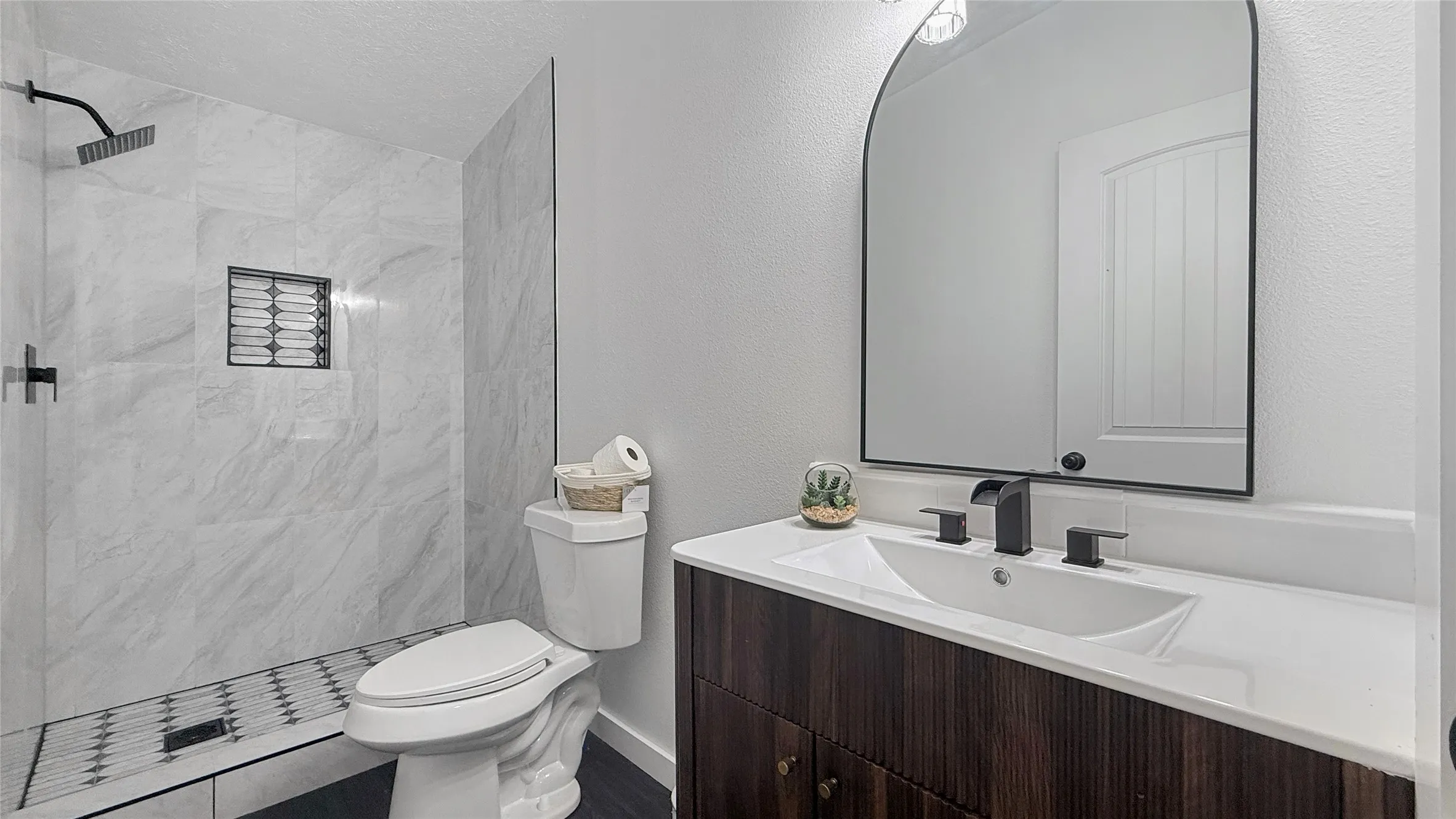 Contemporary bathroom featuring a walk-in shower with large format marble-look tile and a patterned shower floor