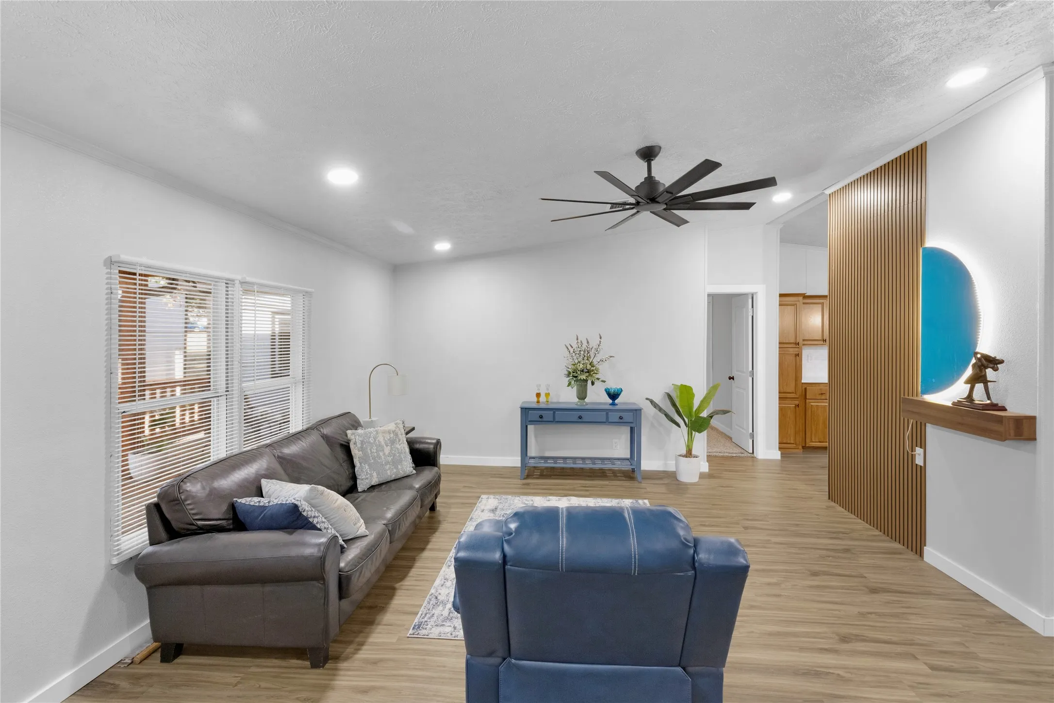 Spacious living area featuring wood-finish flooring, recessed lighting, and a modern ceiling fan