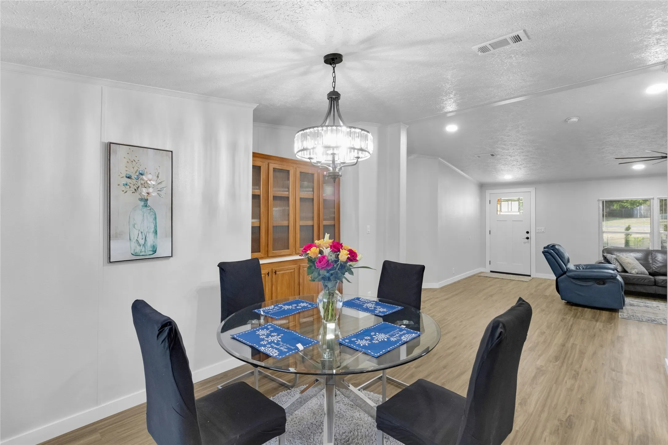 Dining area featuring a contemporary chandelier, wood-finish flooring, and crown molding