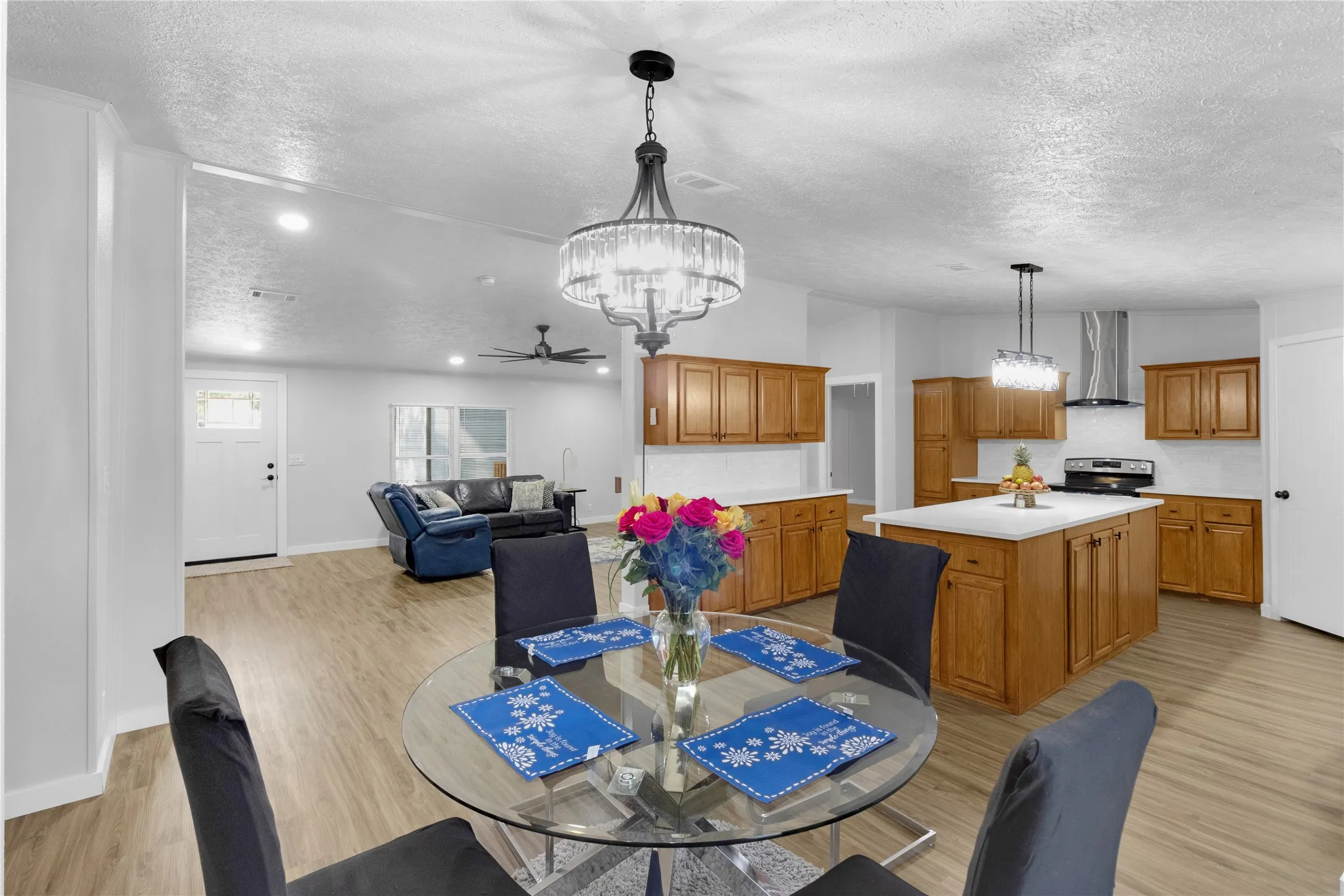 Open concept interior dining - living - kitchen view featuring wood-finish flooring throughout