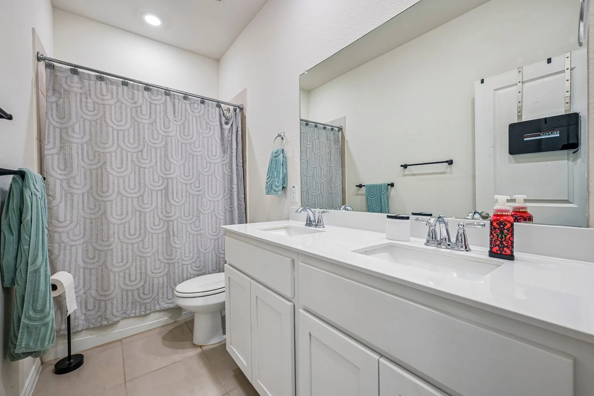 Double vanity featuring integrated sinks, chrome fixtures, and white cabinetry