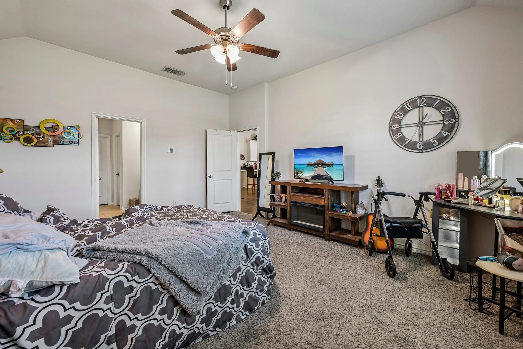 Spacious room featuring vaulted ceilings, a ceiling fan with integrated lighting, and neutral-toned wall paint