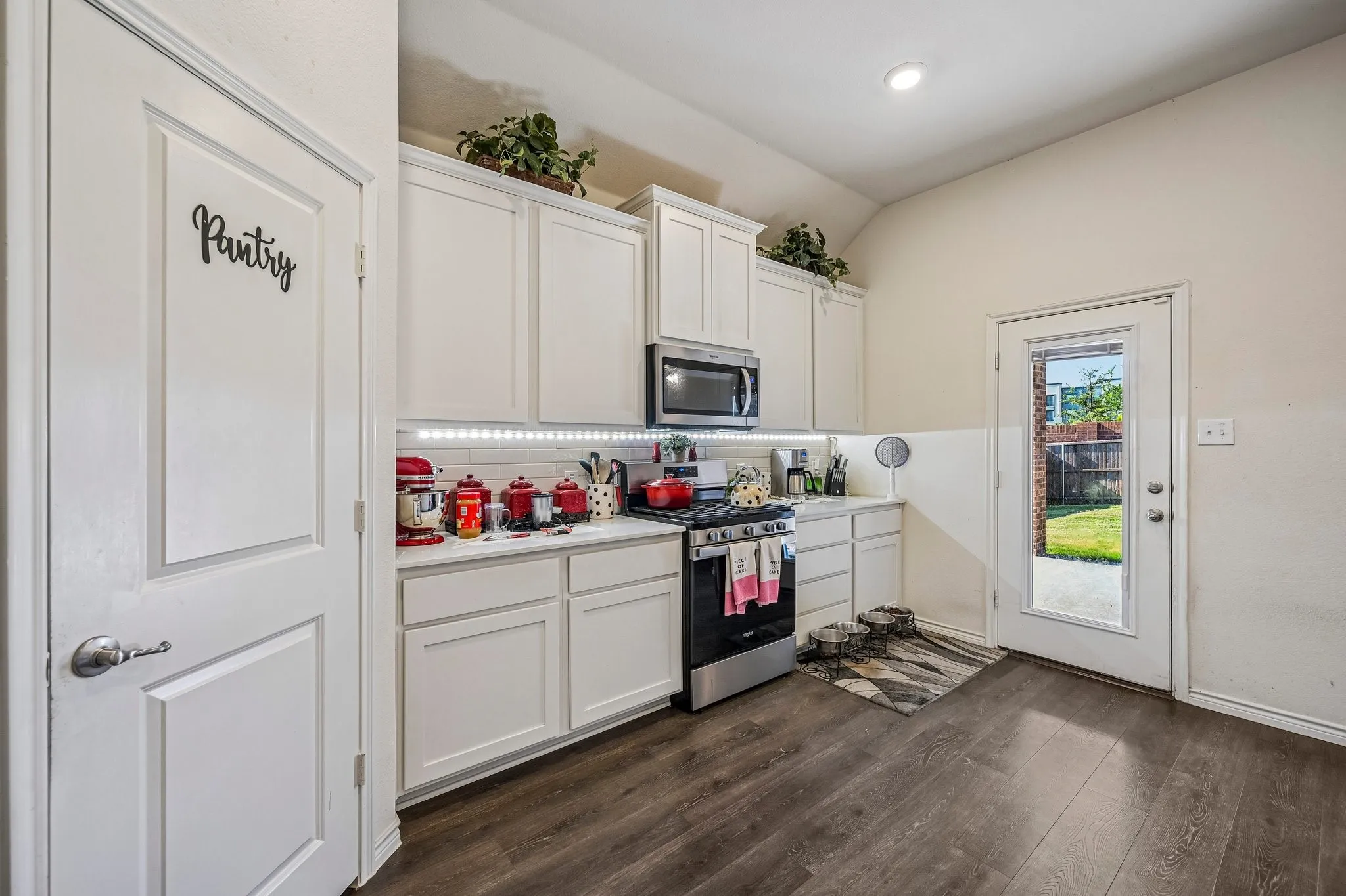 Kitchen featuring white cabinetry, a stainless steel range, and built-in microwave