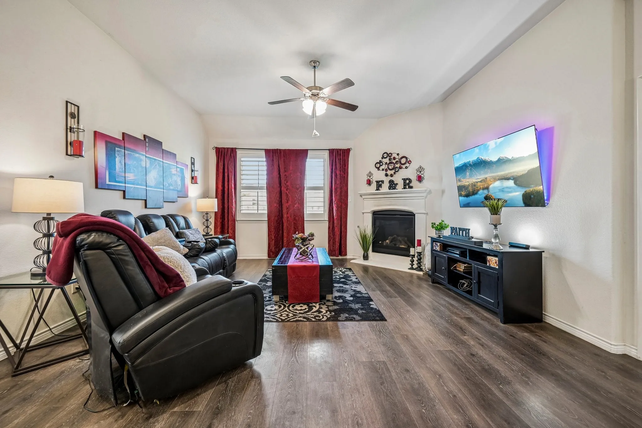 Living area featuring wood-finish flooring, a ceiling fan, and white walls