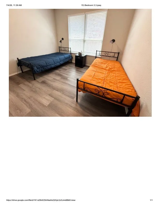 Room featuring wood-finish flooring, neutral wall paint, and a window with horizontal blinds