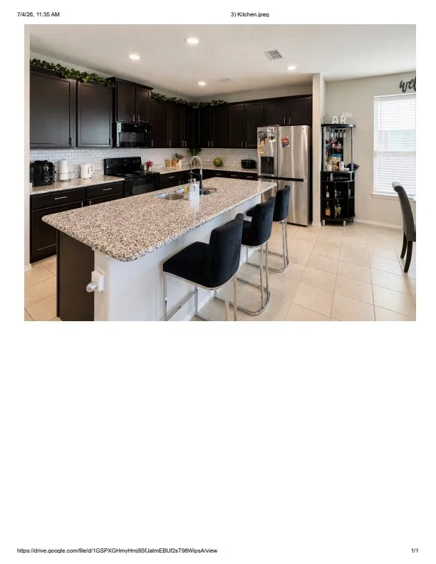 Spacious kitchen featuring a large island with a speckled countertop, dark wood-finish cabinetry, a subway tile backsplash, and recessed lighting