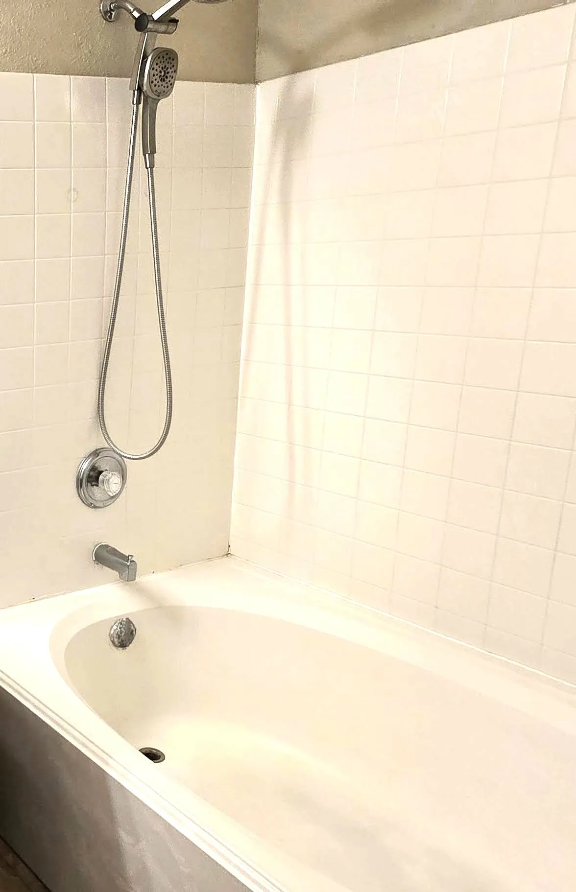 Bathtub with white tile surround and chrome fixtures
