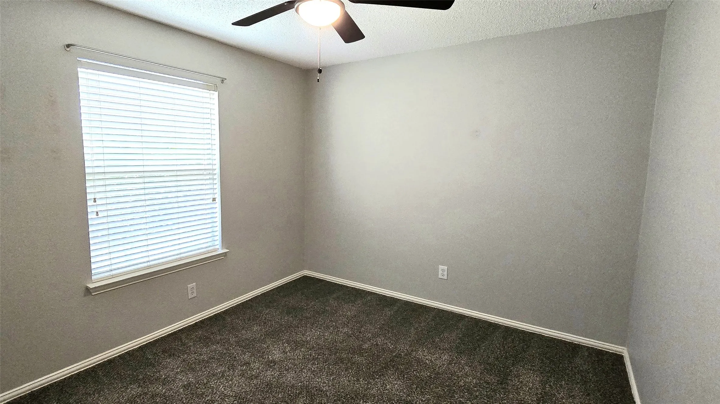 Room featuring carpet flooring, neutral paint, a window with blinds, and a ceiling fan with integrated lighting