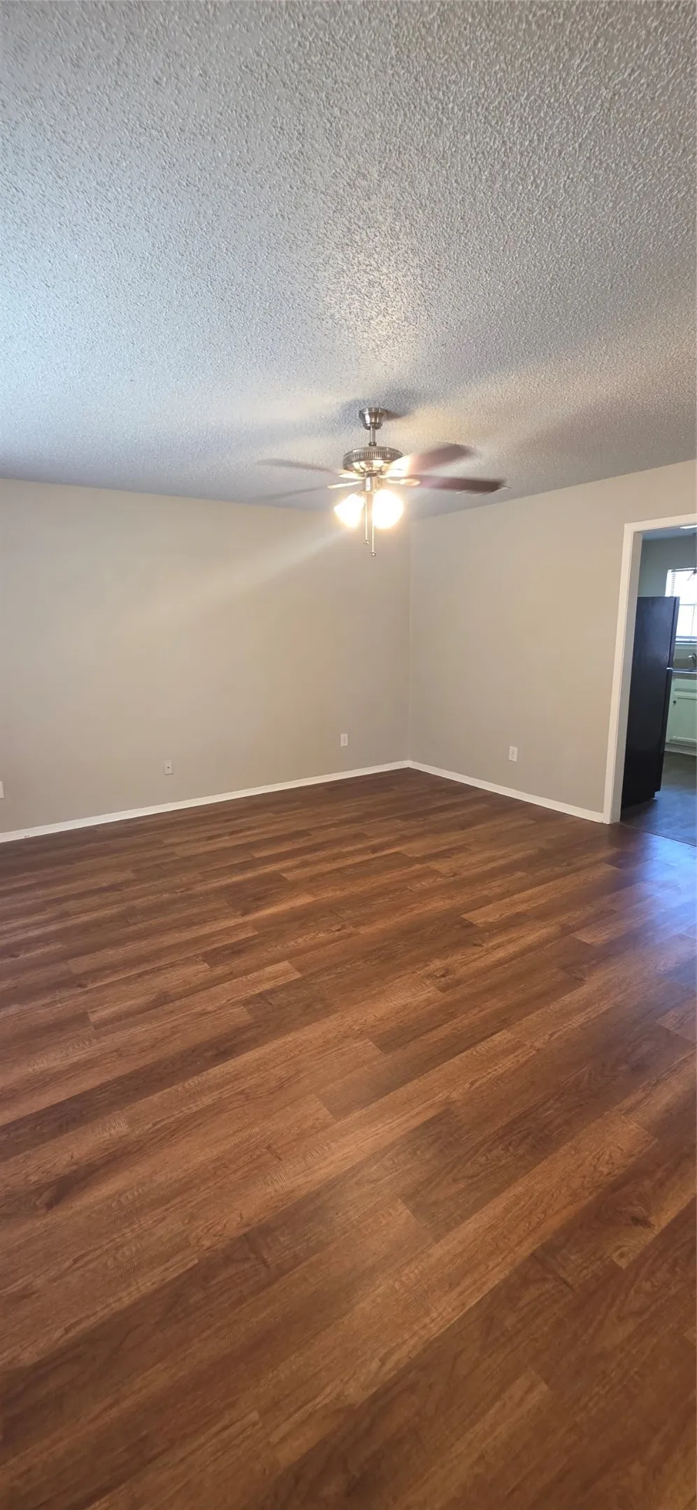 Wood-finish flooring with neutral wall tones and a ceiling fan