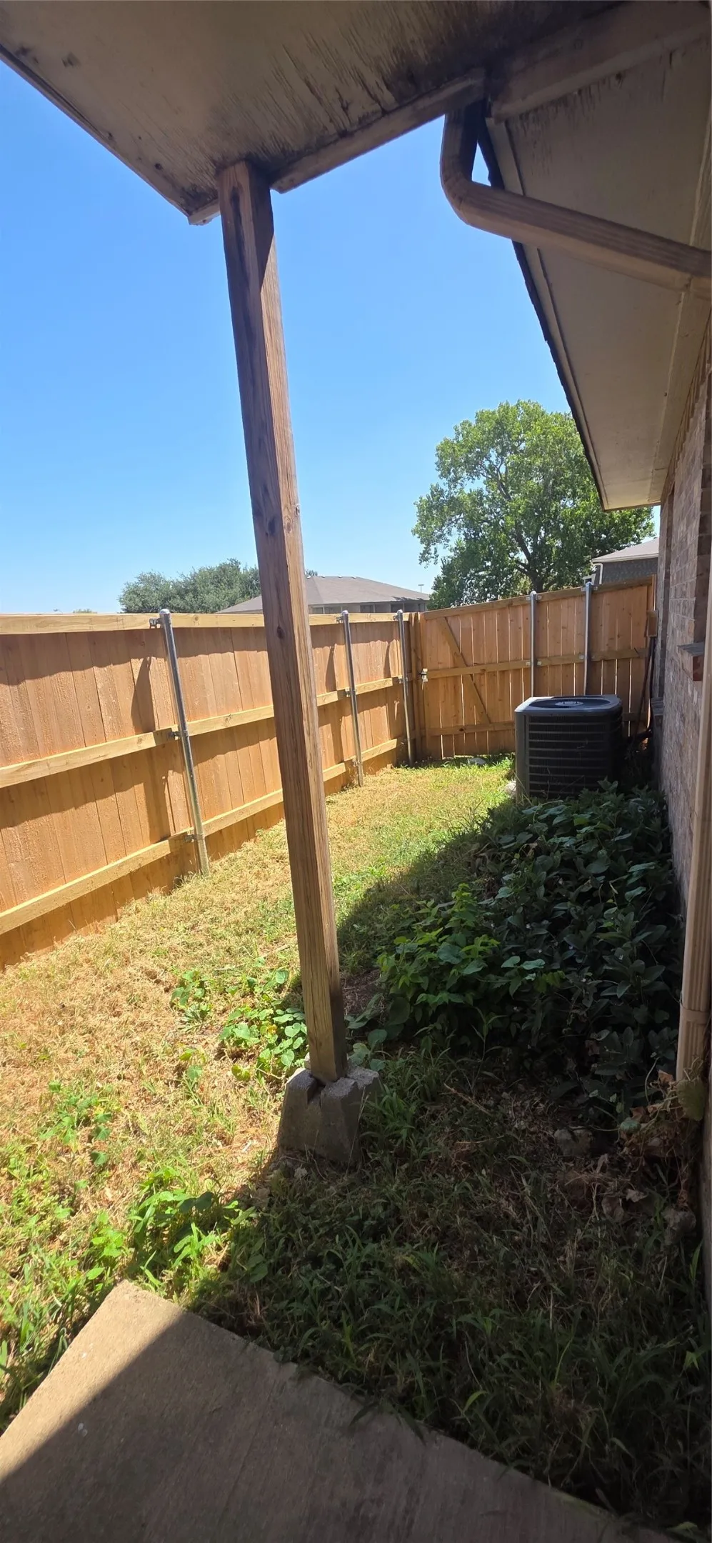 Covered patio area with concrete pad and wood support beams