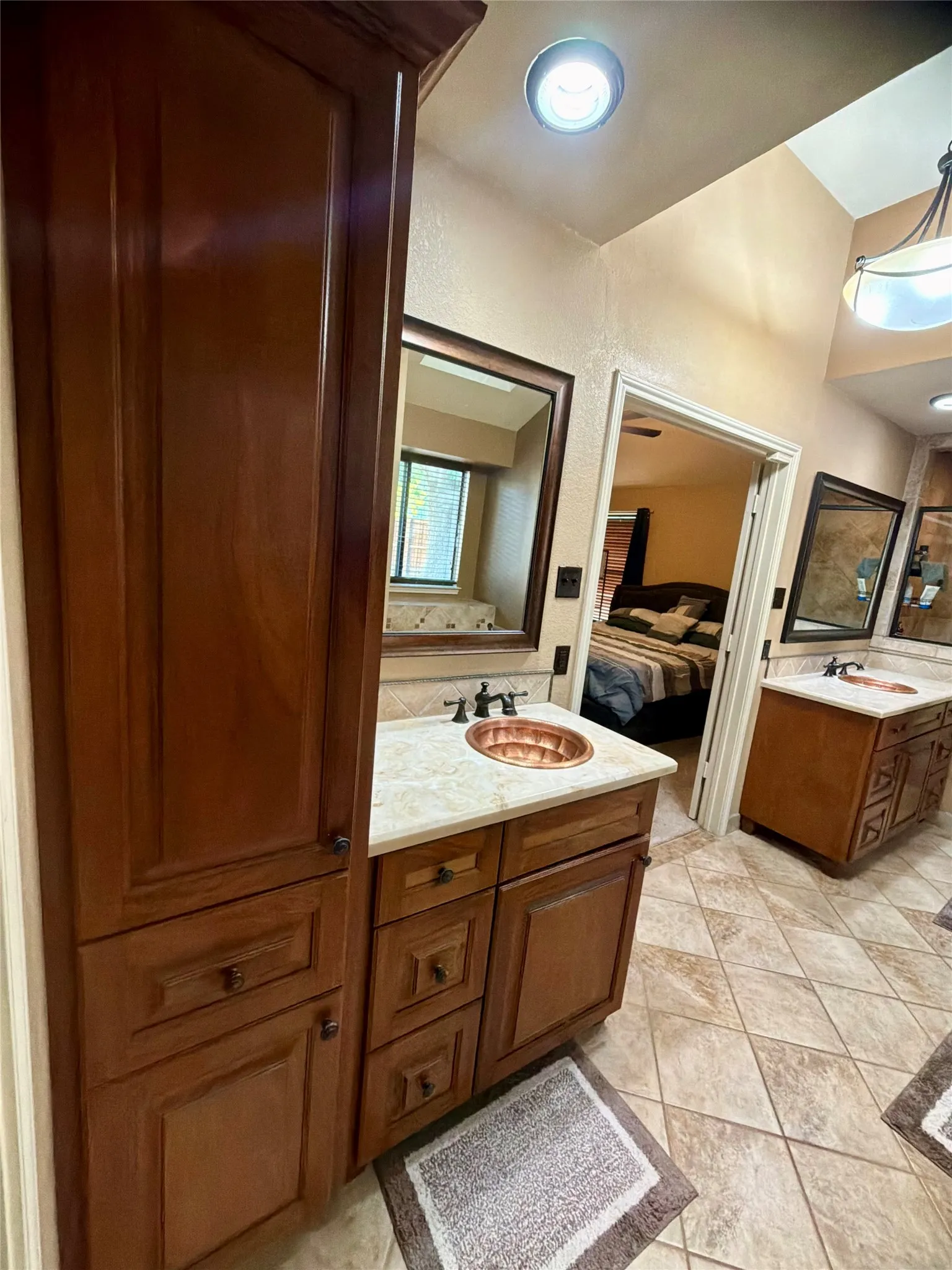 Dual vanity with built in wood cabinetry, upgraded countertops, enclosing beautiful custom rare copper sinks!