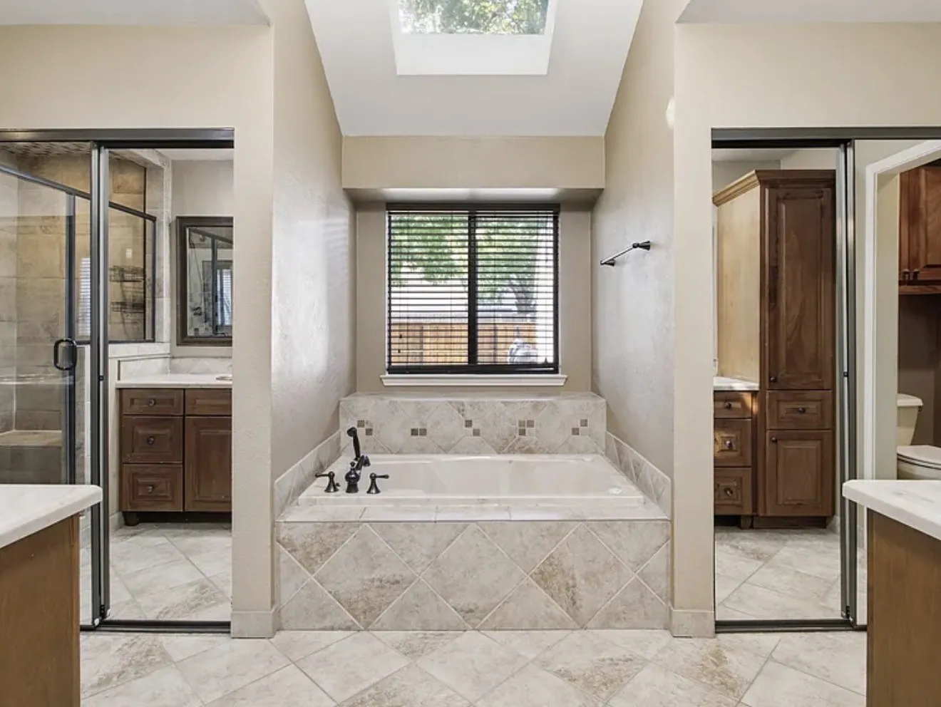Built-in soaking tub with tile surround, paired with a skylight and window