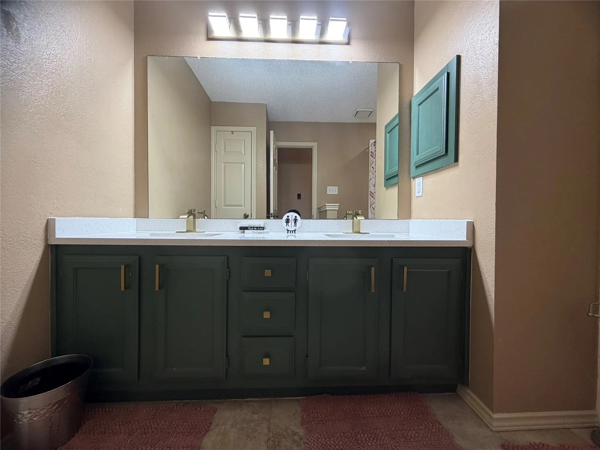 Secondary bathroom with double sinks and beautiful gold accent hardware to bring out the popular green cabinets!