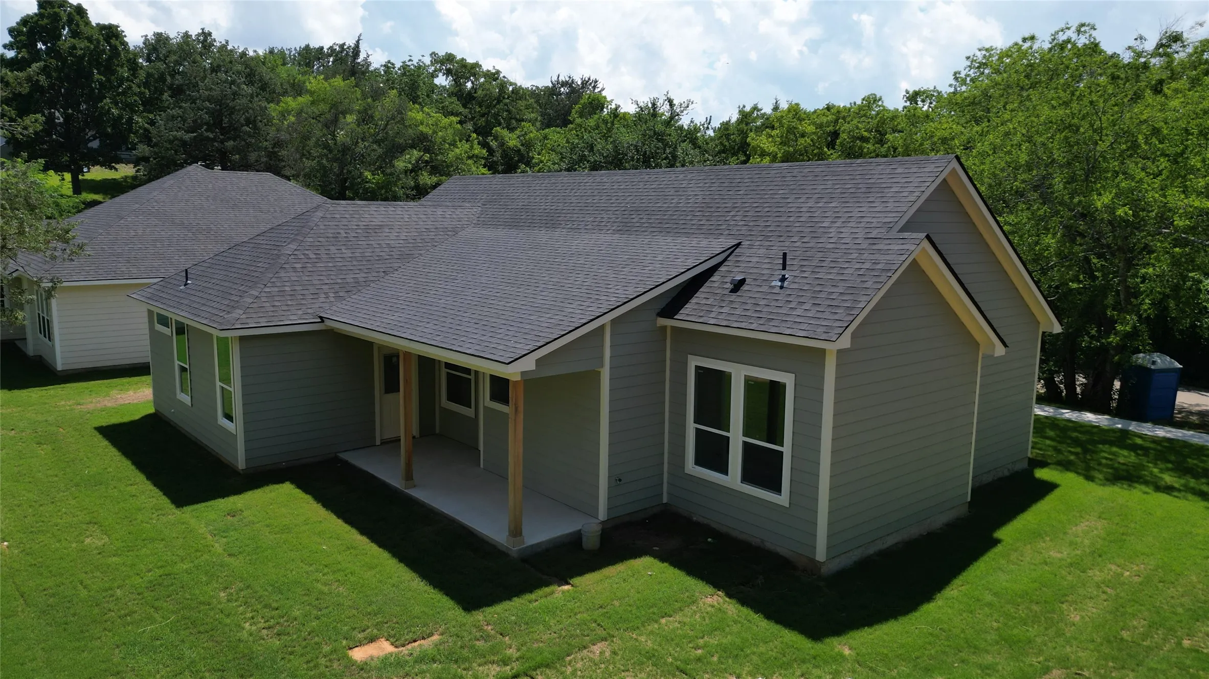 Charming ranch-style home featuring a gable roof with architectural interest, neutral exterior siding, and a covered front porch