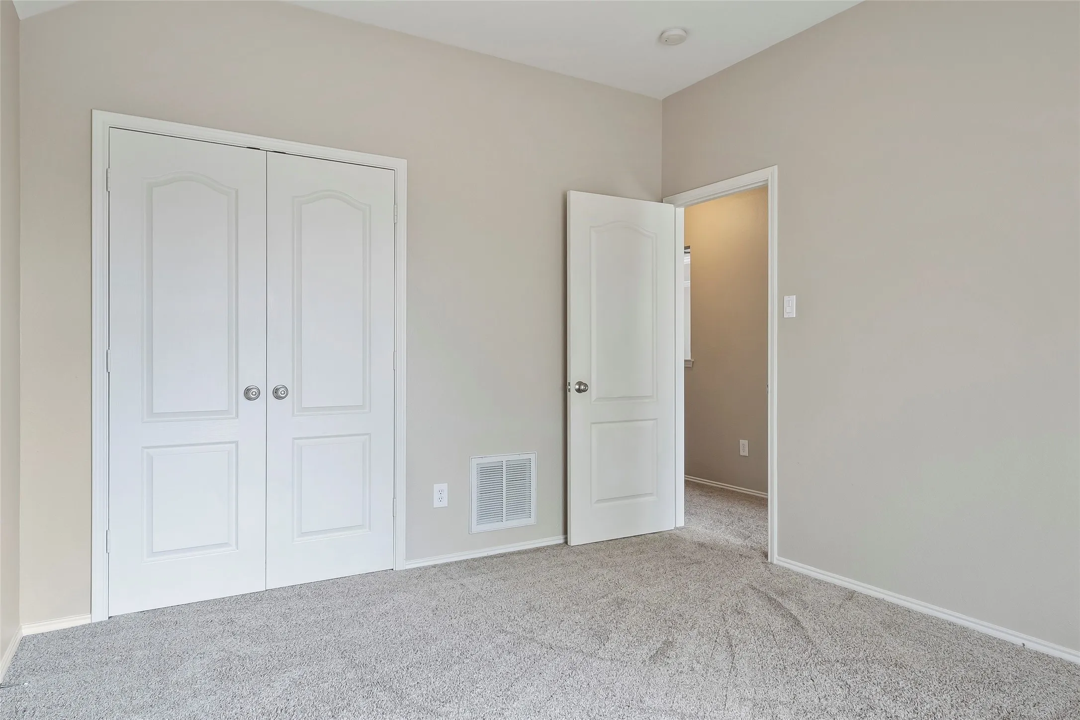 Neutral-toned walls complement the gray carpeting