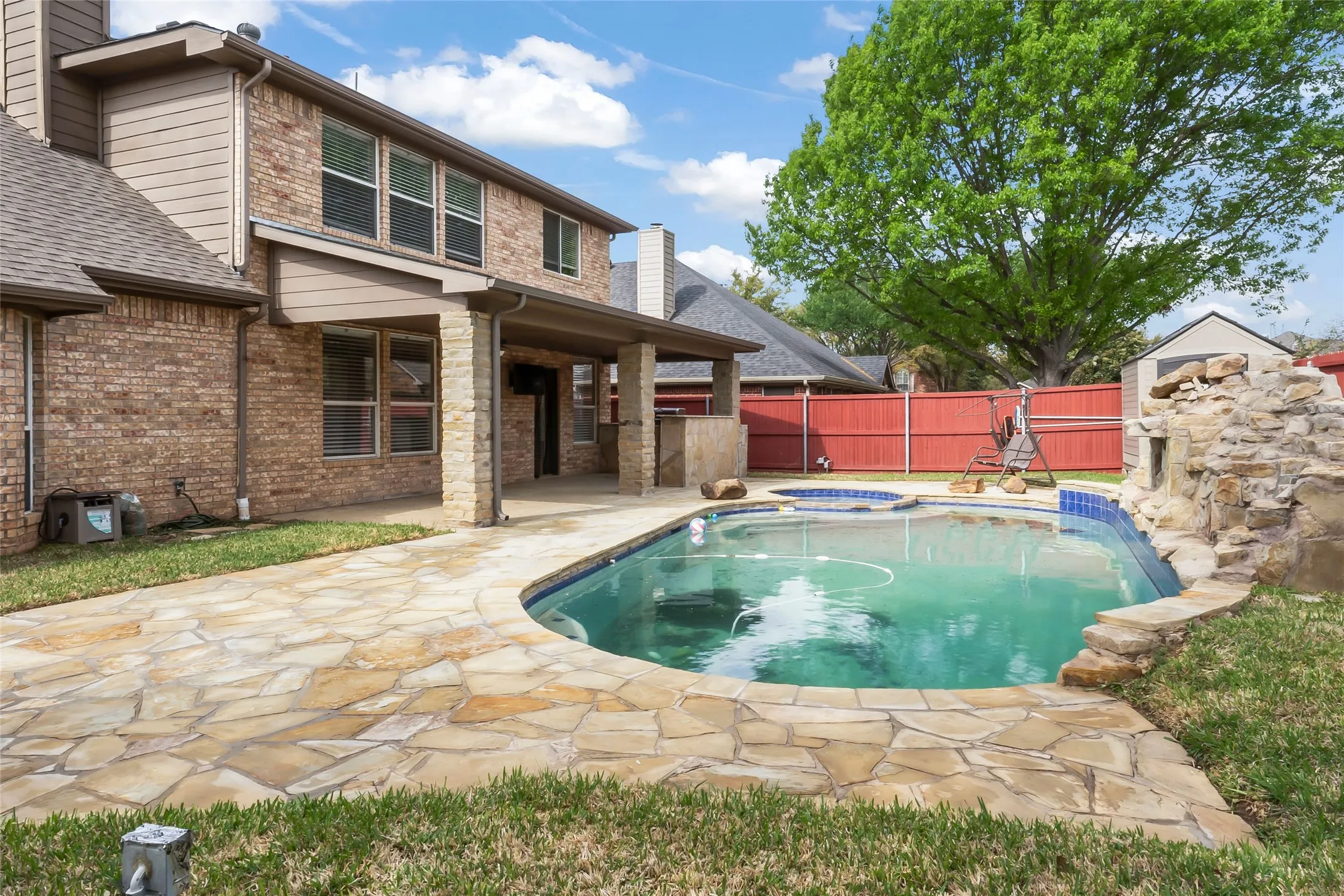 Backyard oasis featuring a curvilinear pool with an integrated spa