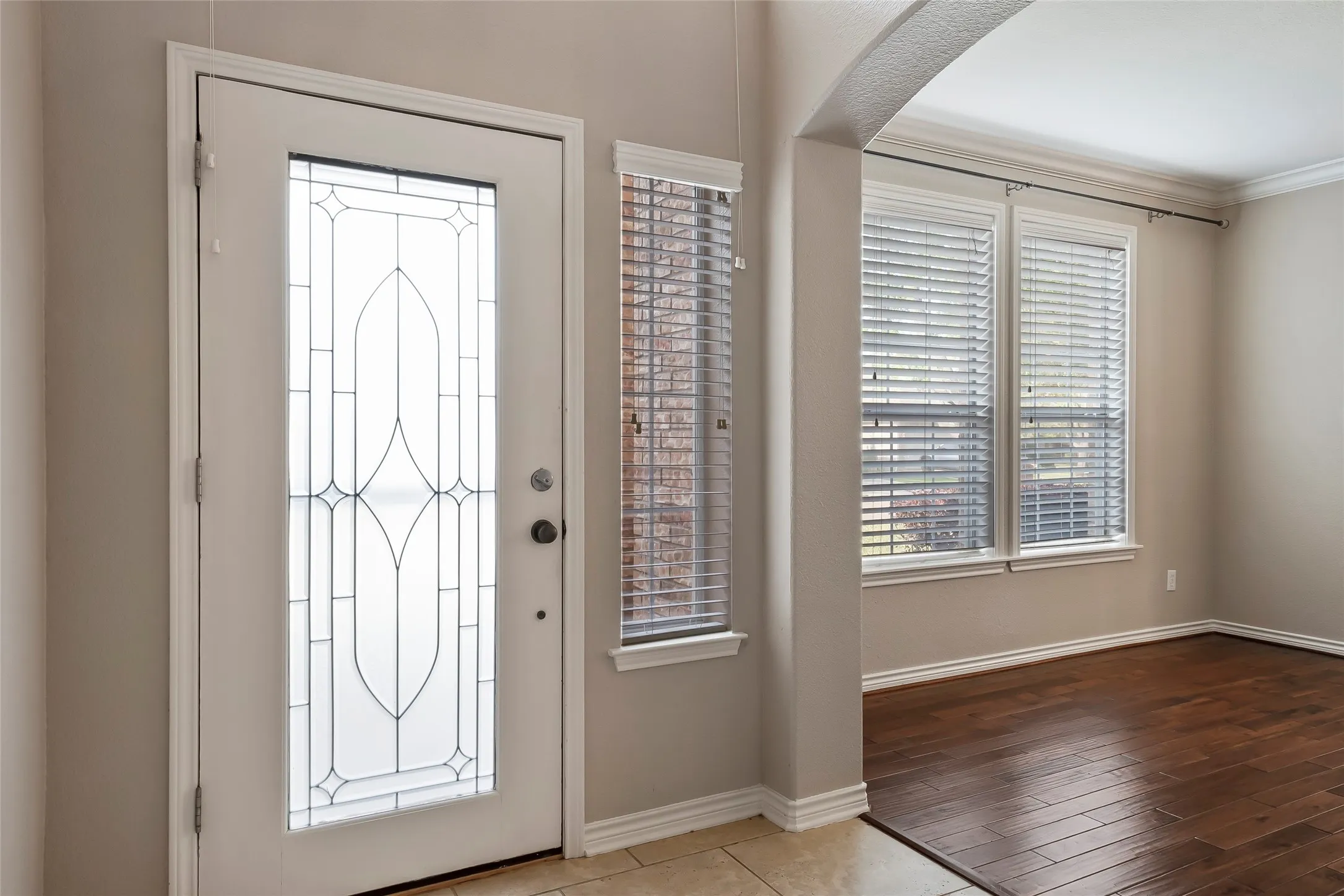 Entryway featuring a decorative glass panel door, tile flooring, and light neutral wall colors