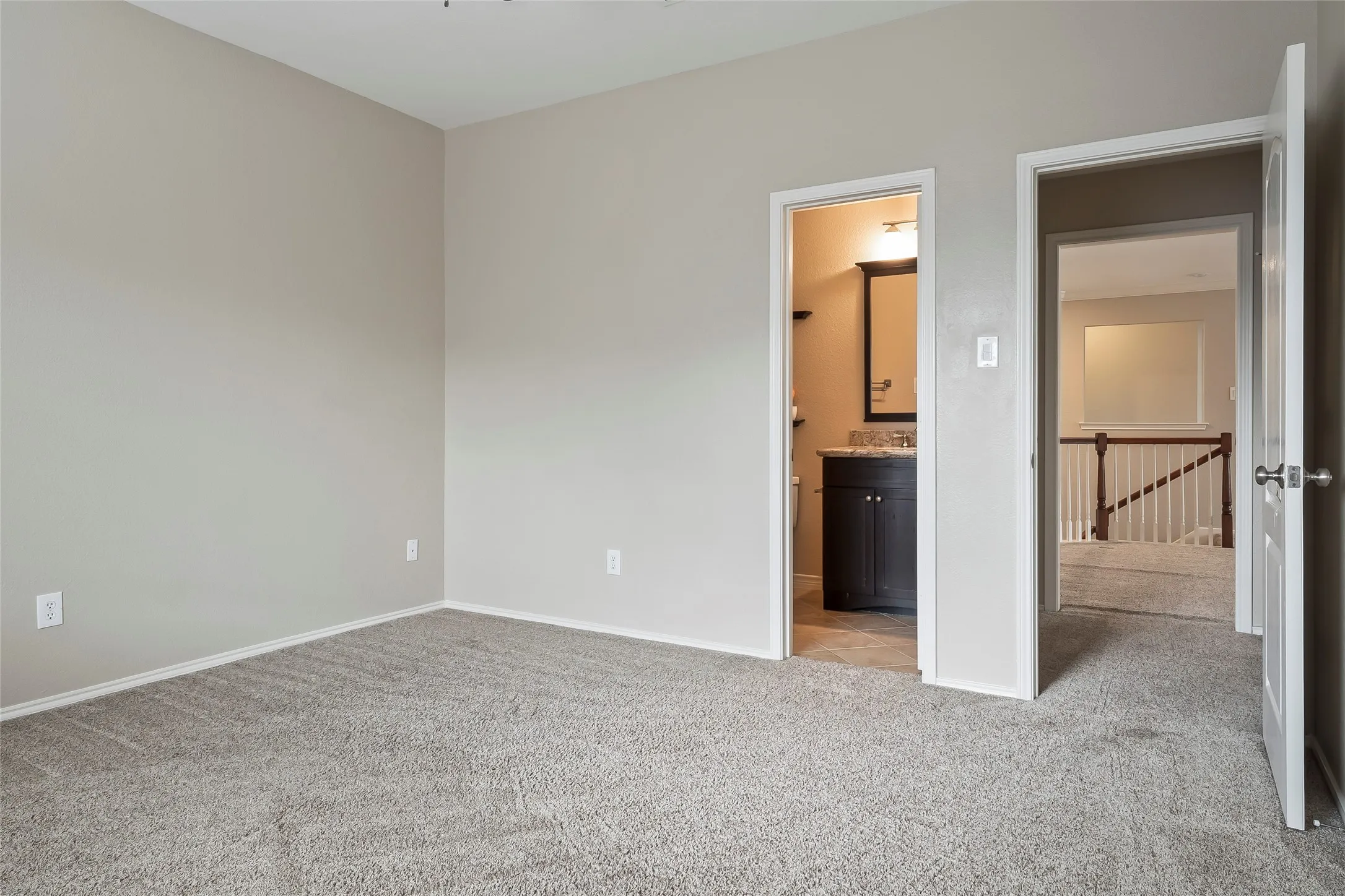 Spacious room featuring neutral carpeting and wall tones