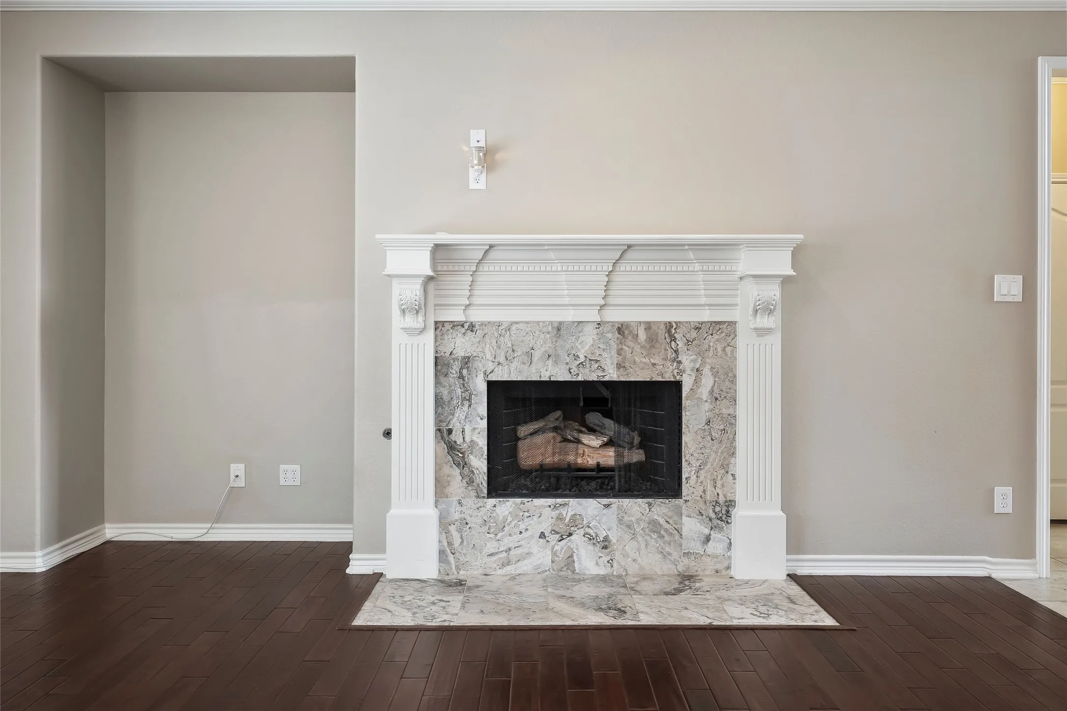 Fireplace featuring an ornate white mantel, stone surround, and gas insert