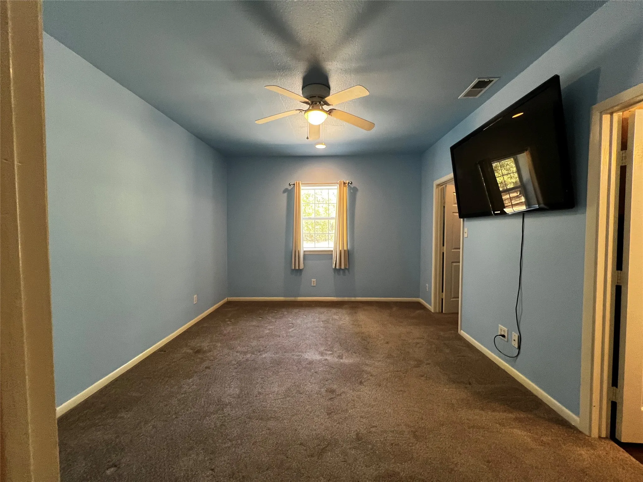 Open Living Space facing the entry door from the Garage Shop and the mini hall to one of the unfinished bedrooms.