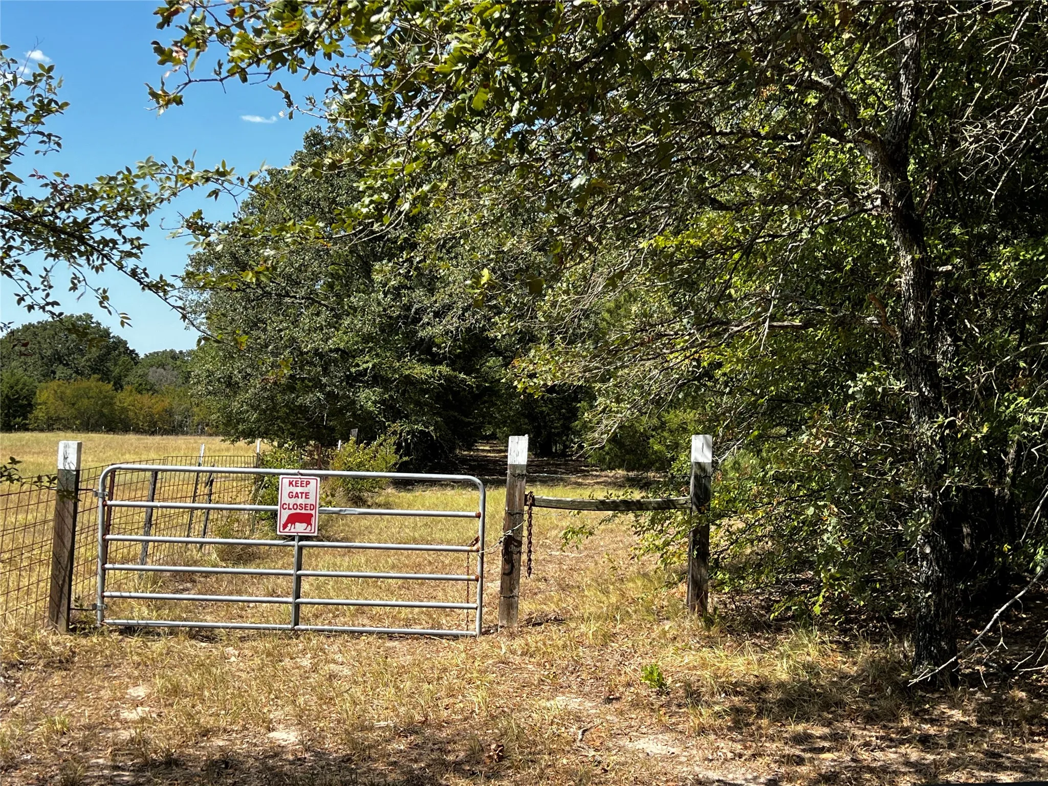 Gated entrance on cross fence between the front acreage and the back woods and pasture acreage .  This gate provides access to the cleared path along the west property line.