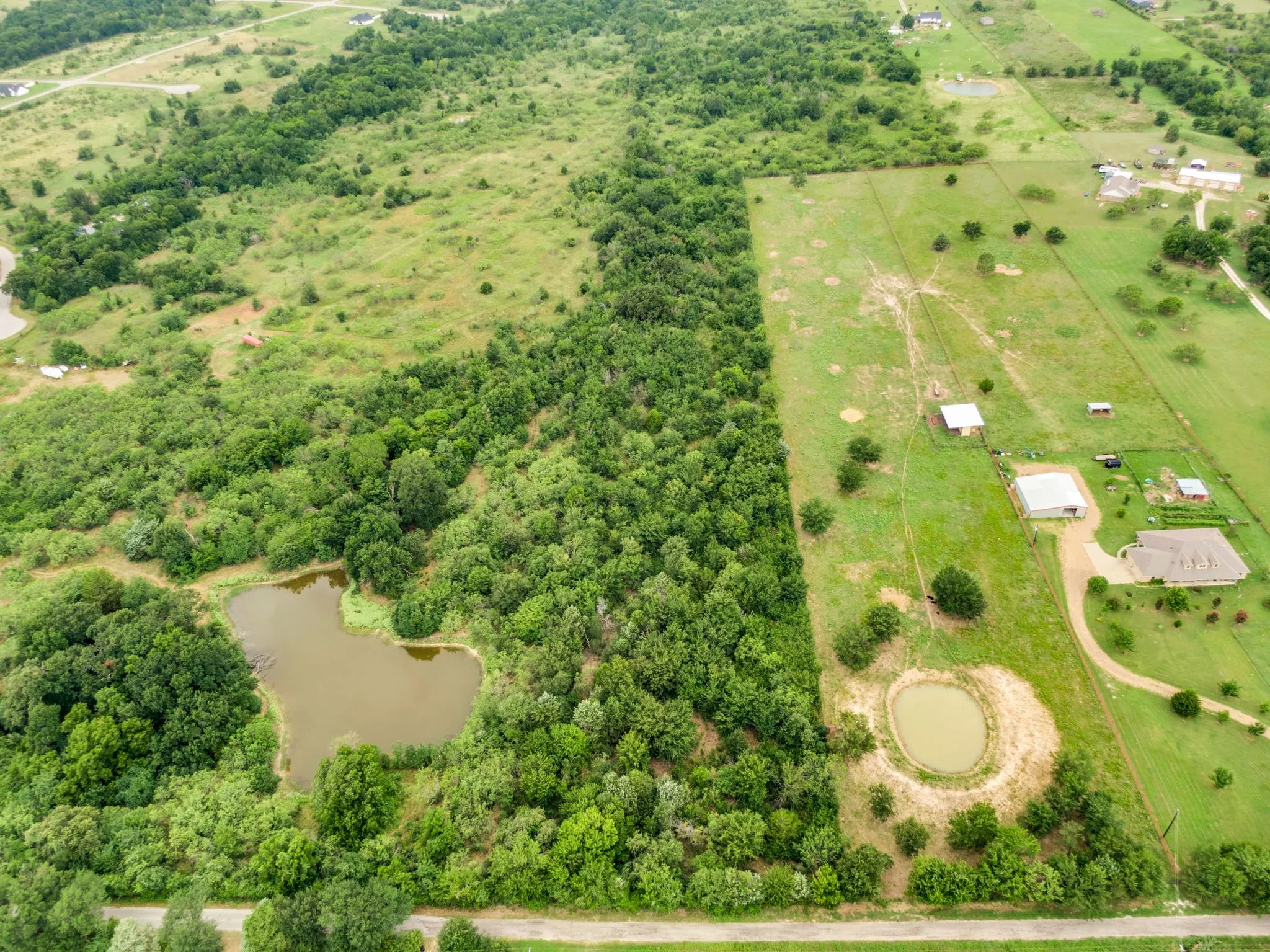 Expansive land parcel featuring diverse topography, including wooded areas and open fields