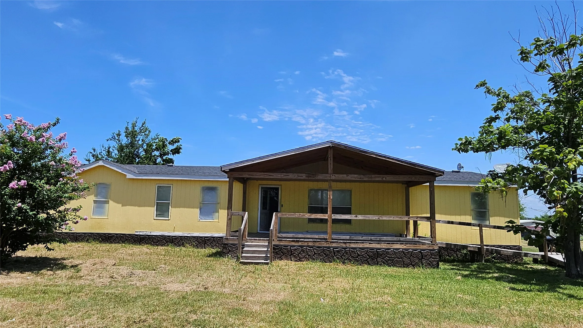 Large front porch with a side ramp.
