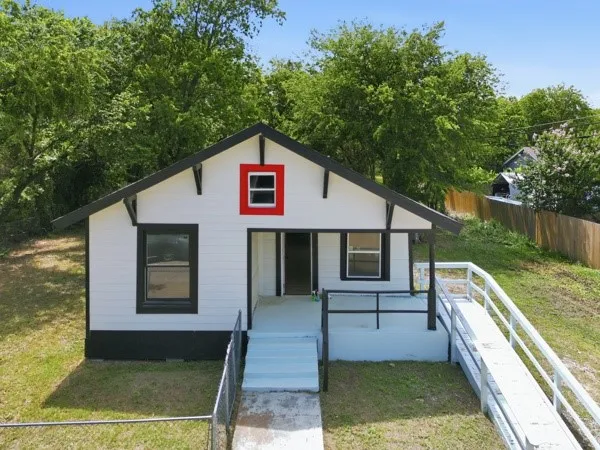 White siding exterior with a contrasting black trim and red accent window