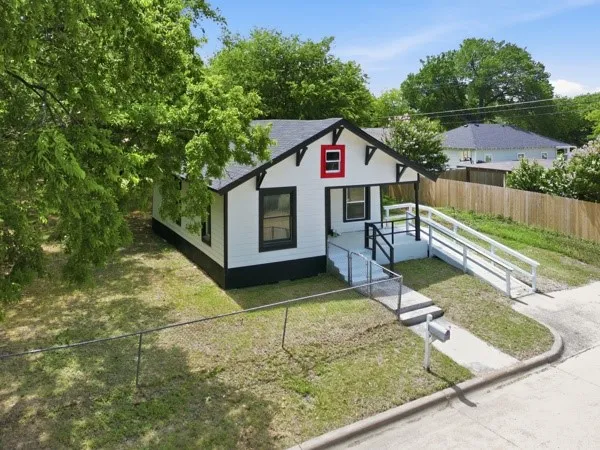 White siding exterior with black trim accents and a contrasting red window frame