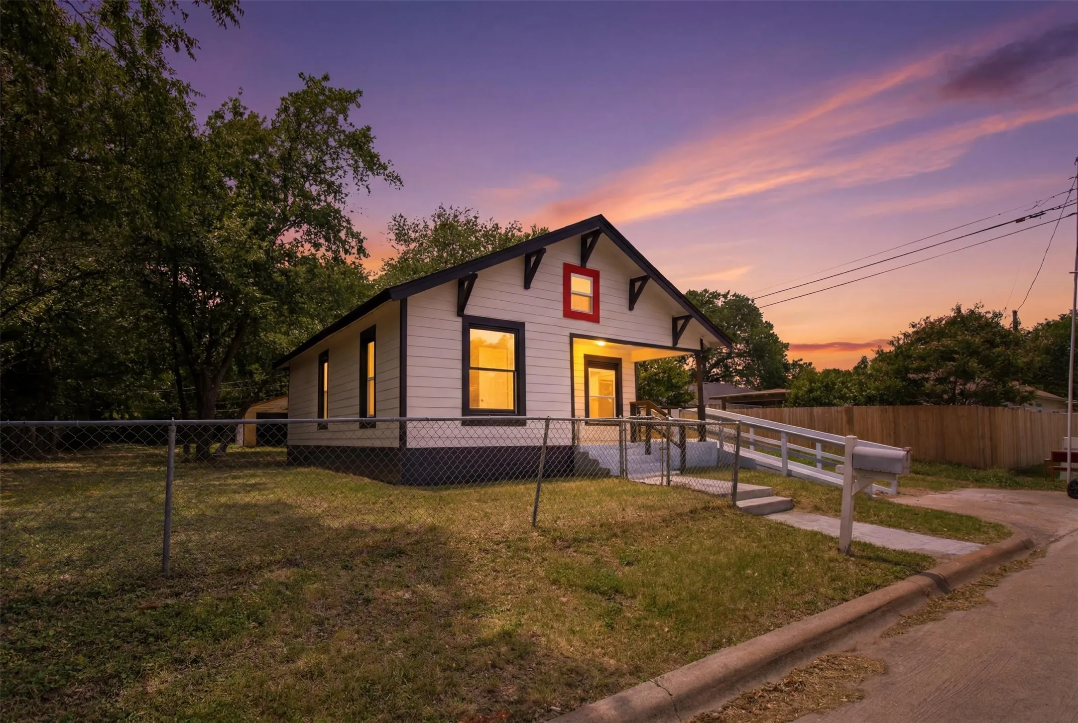 Gable-roof property featuring white siding and black trim details