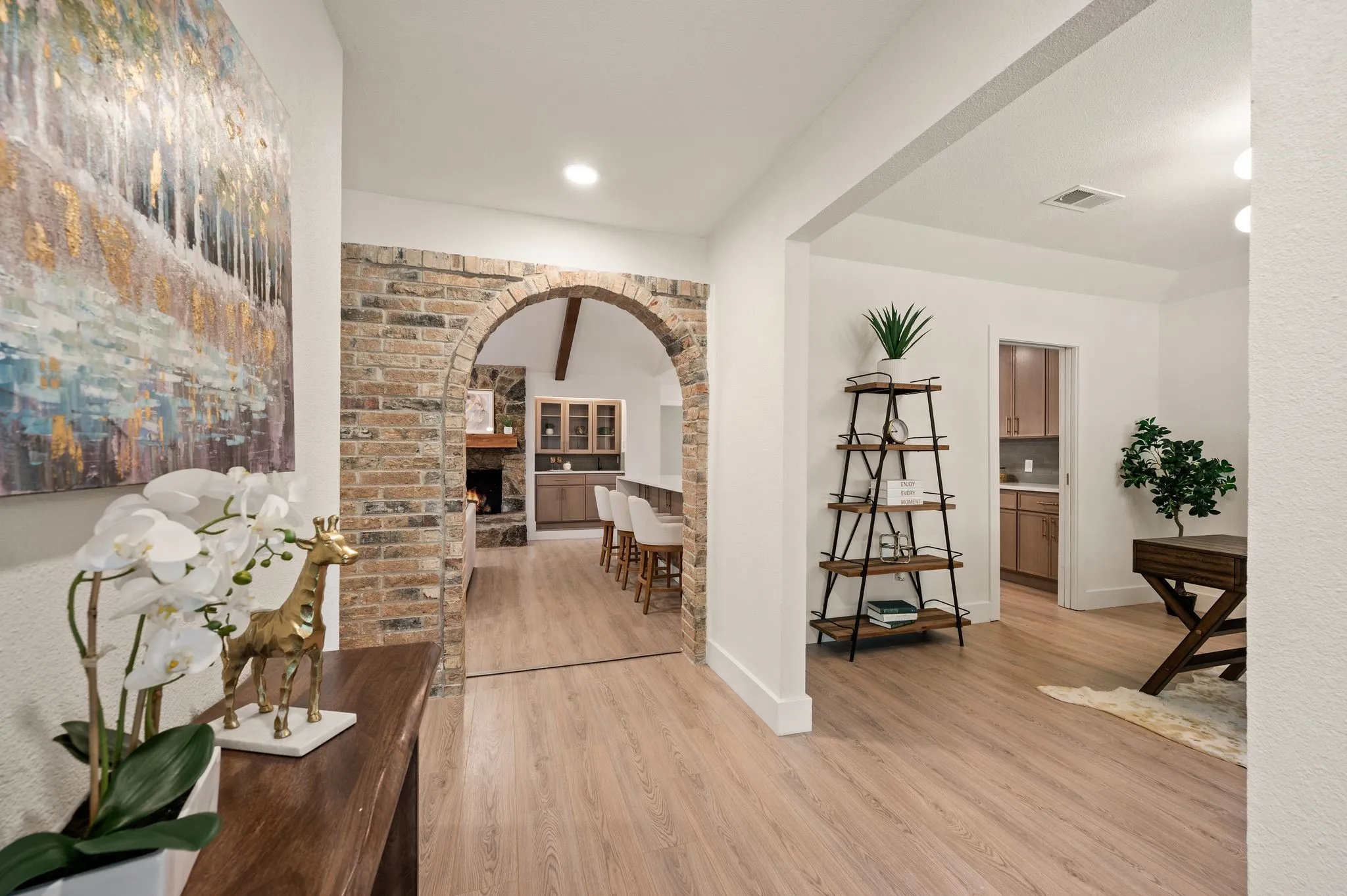 Original brickwork creates a beautiful transition between the entry, office, and open living spaces.
