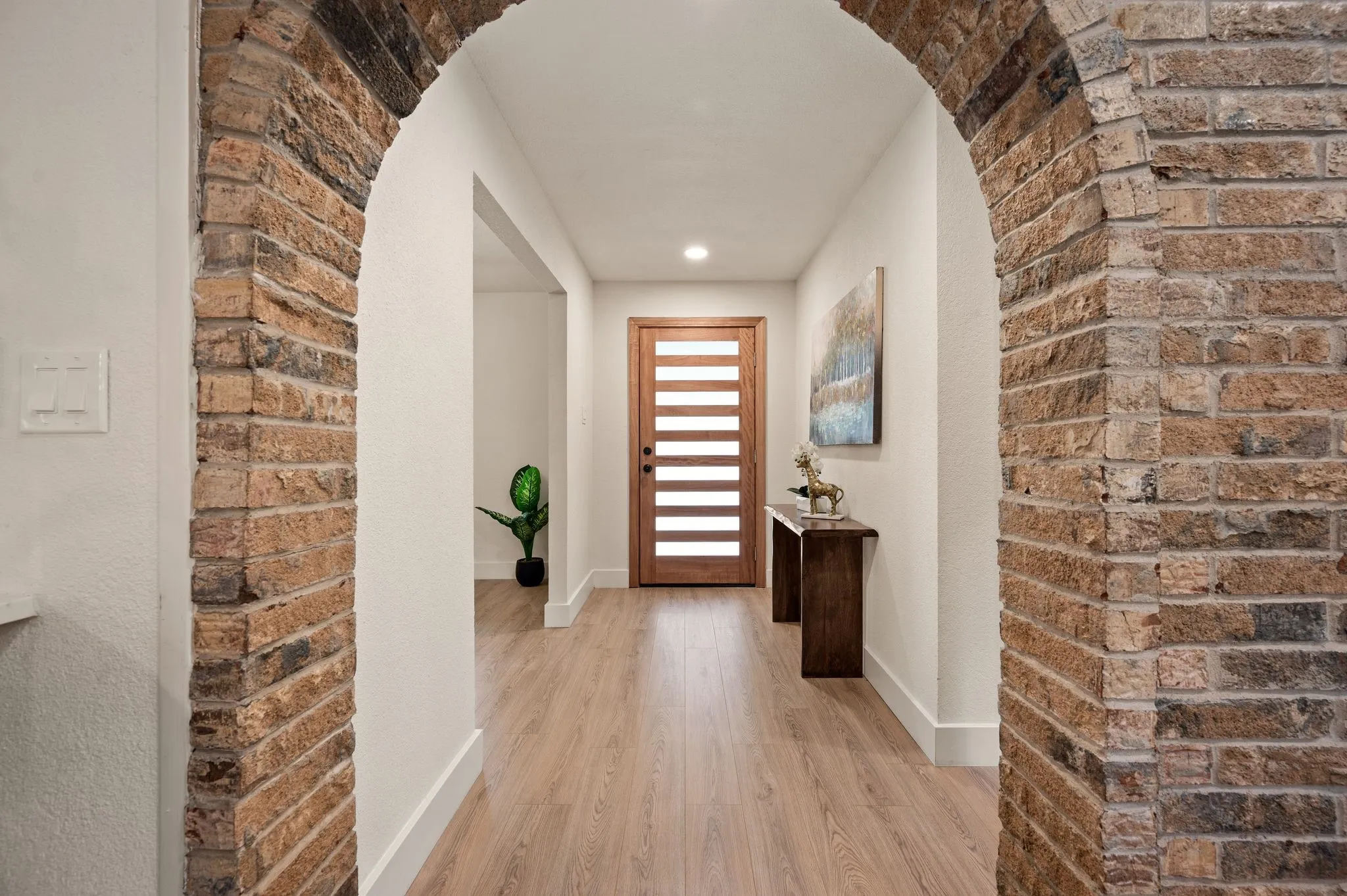 The preserved brick archway frames a memorable entrance where original character meets modern design.