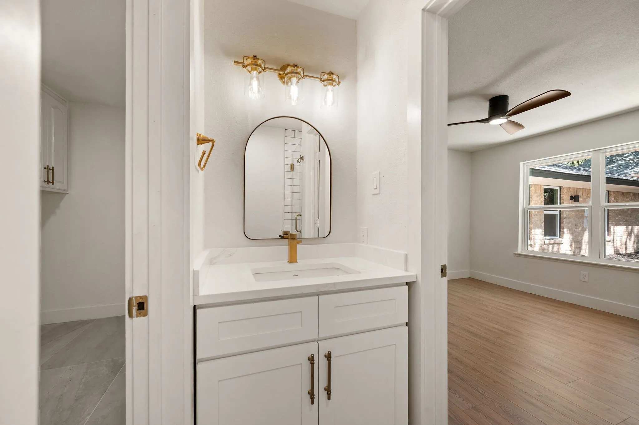 A private vanity with quartz counters and champagne-bronze fixtures adds convenience and thoughtful separation.