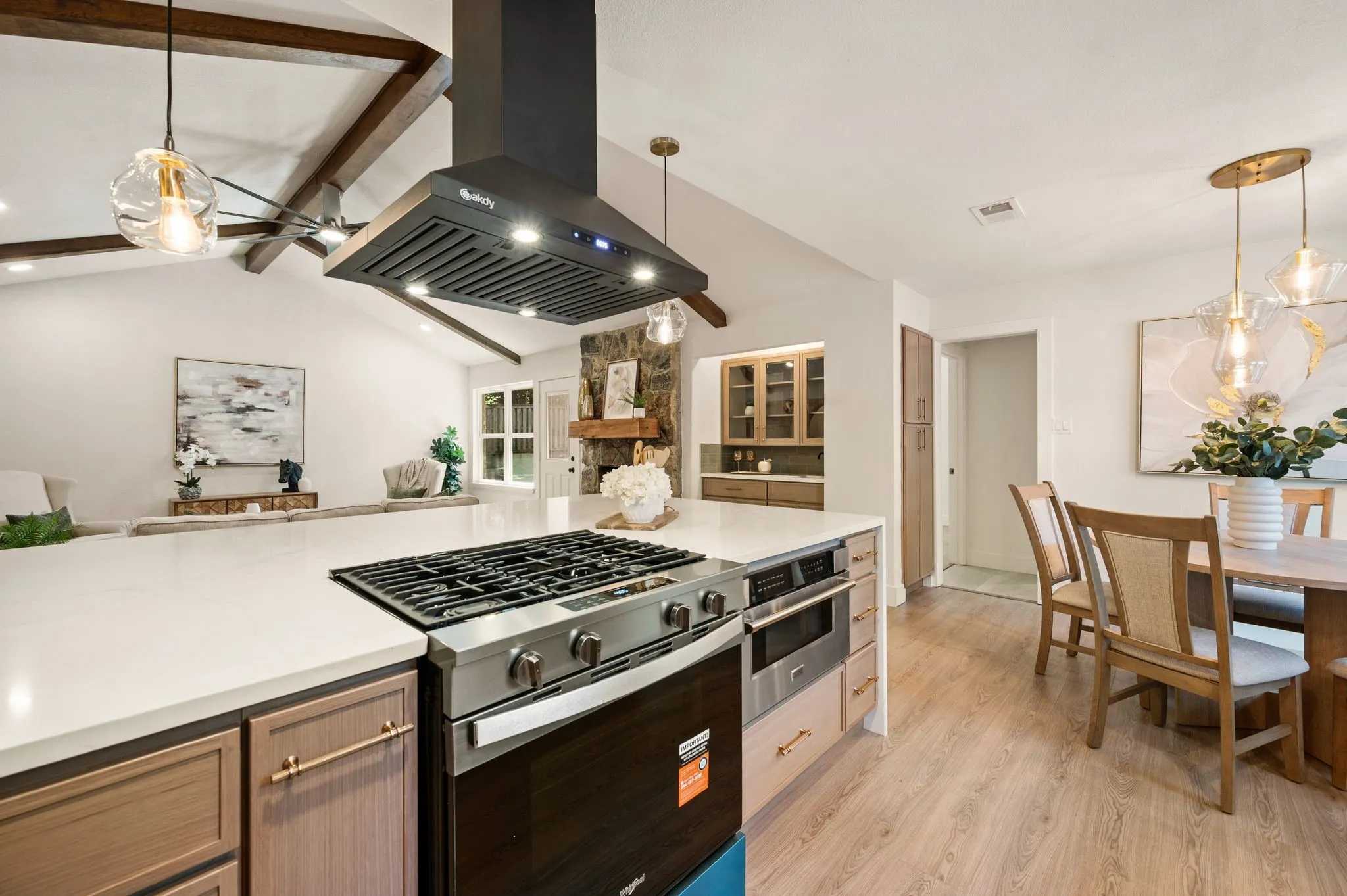 Cook at the center of the conversation, with the open kitchen overlooking the living room, fireplace, and breakfast nook.