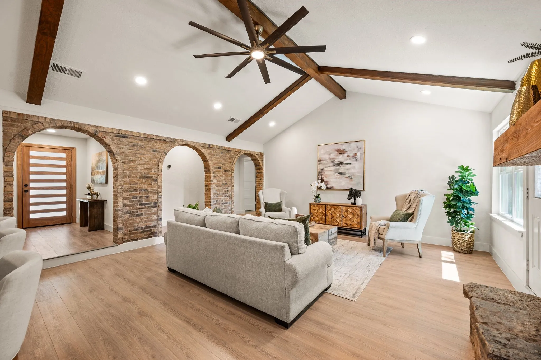 Sunlight pours across the spacious living room while original brick arches give the home a character that cannot be replicated.