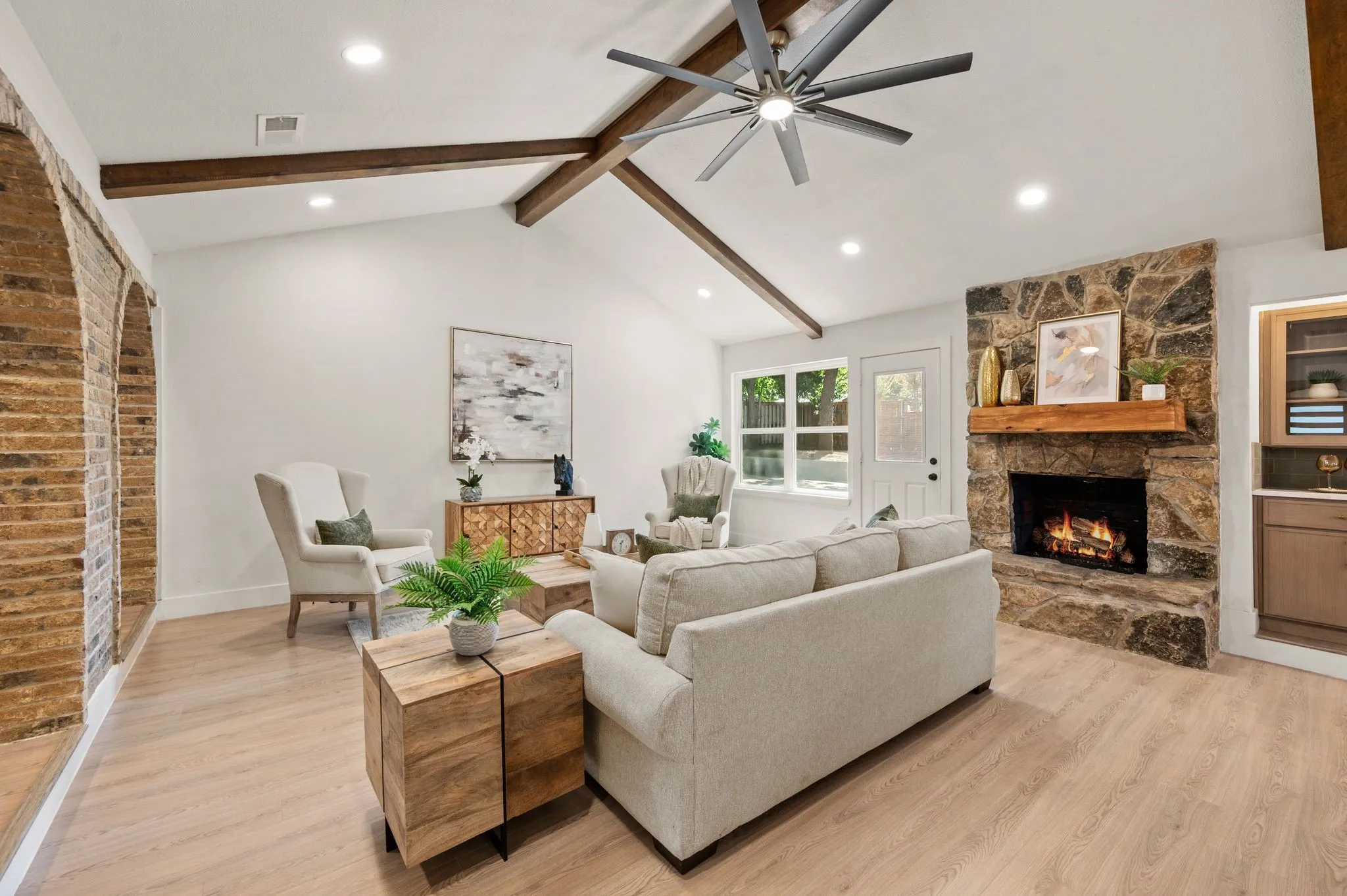 Exposed beams and a dramatic stone fireplace give the living room the warmth and character of a custom home.