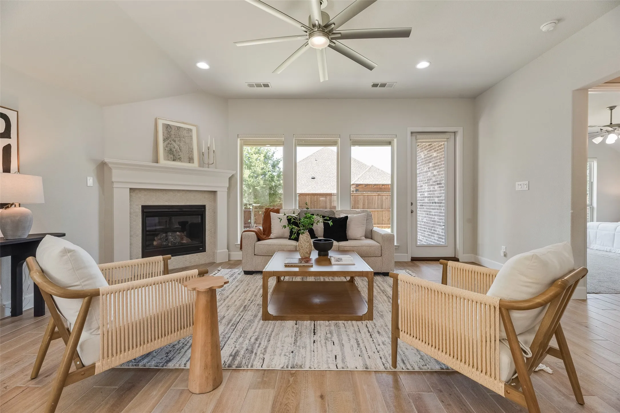 Spacious living room with natural light, ceiling fence, and elegant fireplace.