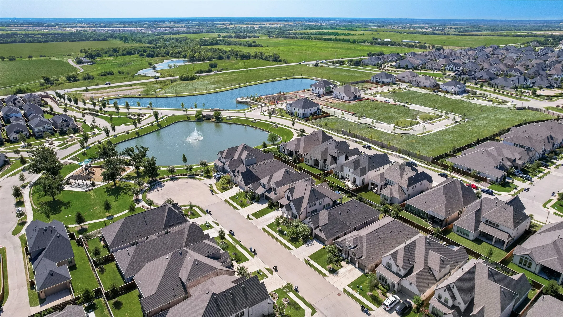 Aerial perspective showcasing a residential community with numerous homes and surrounding green spaces
