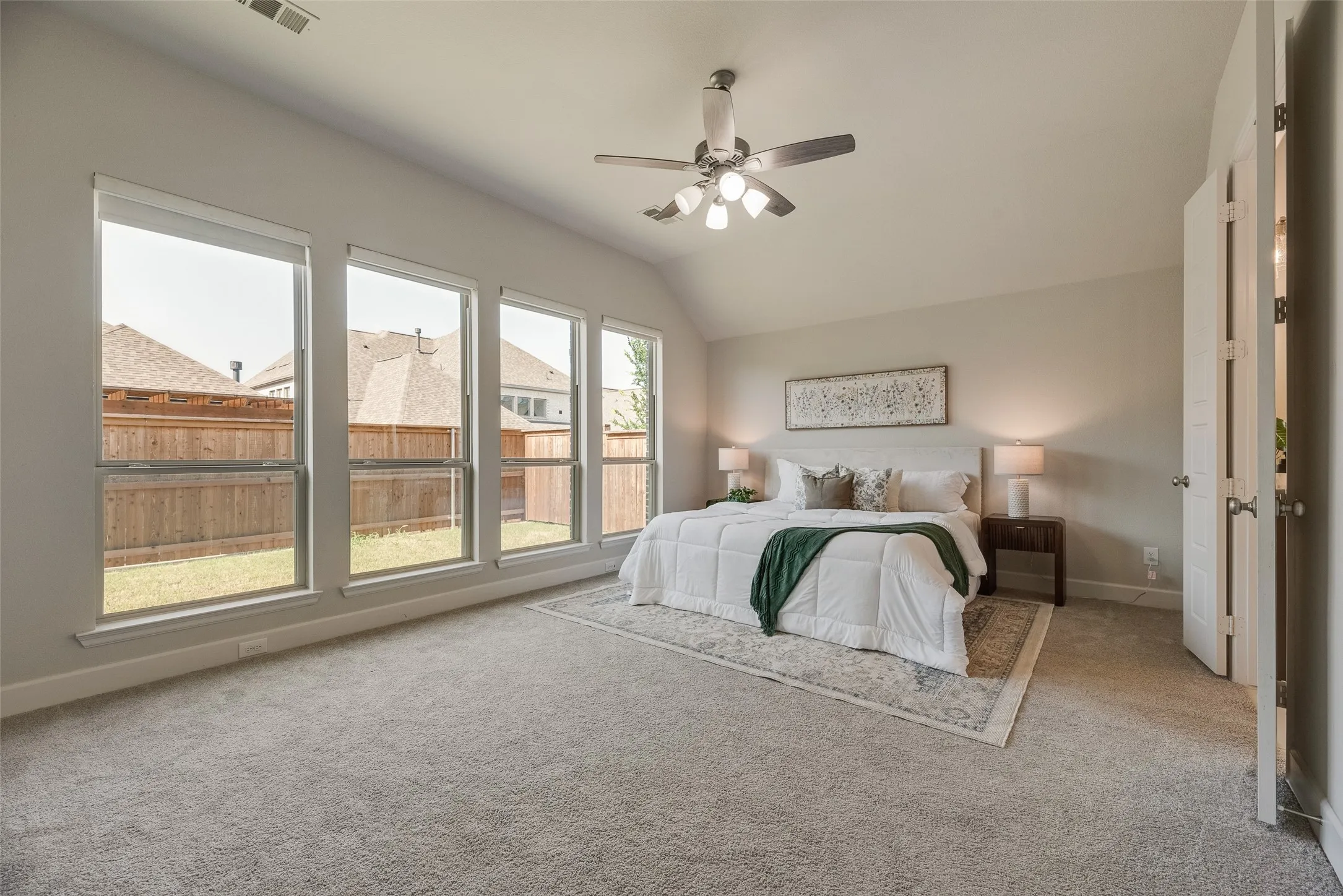 Oversized primary bedroom features four floor to ceiling windows for added natural light and appeal in this charming home.